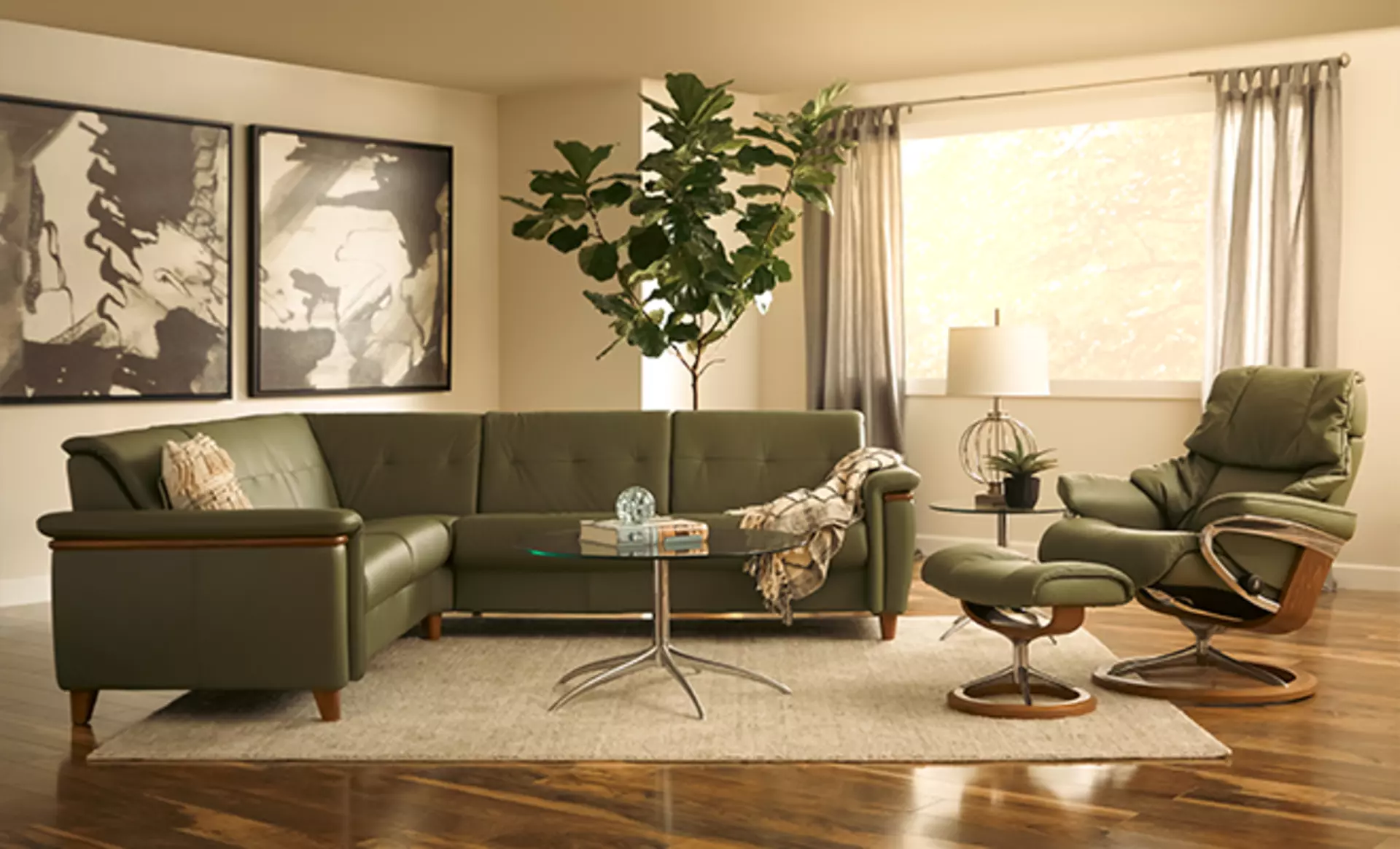 Das Stressless Flora Sofa mit dem Reno Relaxsessel in Shadow Green Leder gepolstert mit Polierten Teak-Holz Akzenten bilden eine erholsame Polstergarnitur. 