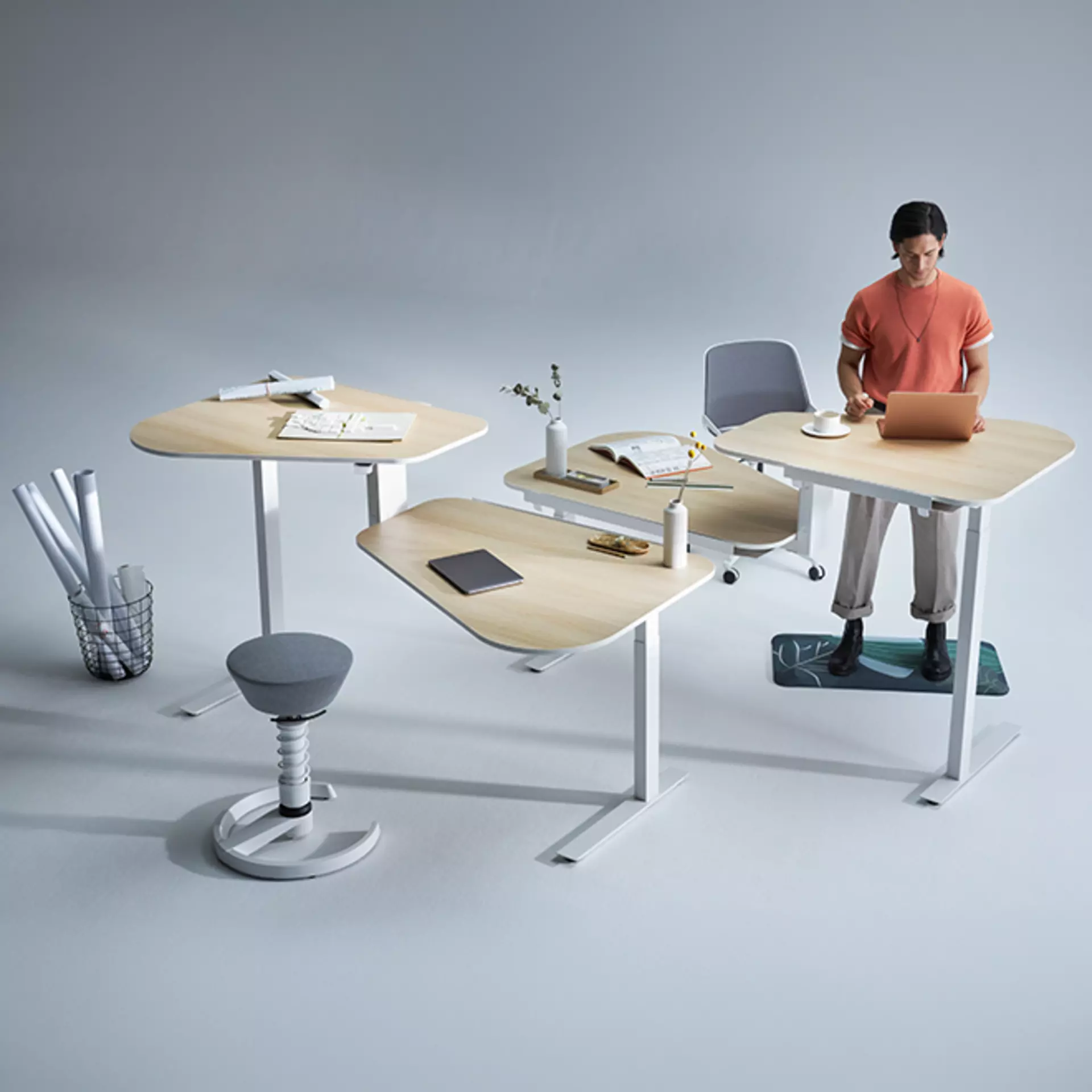 Ein Mann steht auf seiner aeris Muvmat Bodenmatte an dem Steharbeitsplatz seines aeris active office desk 