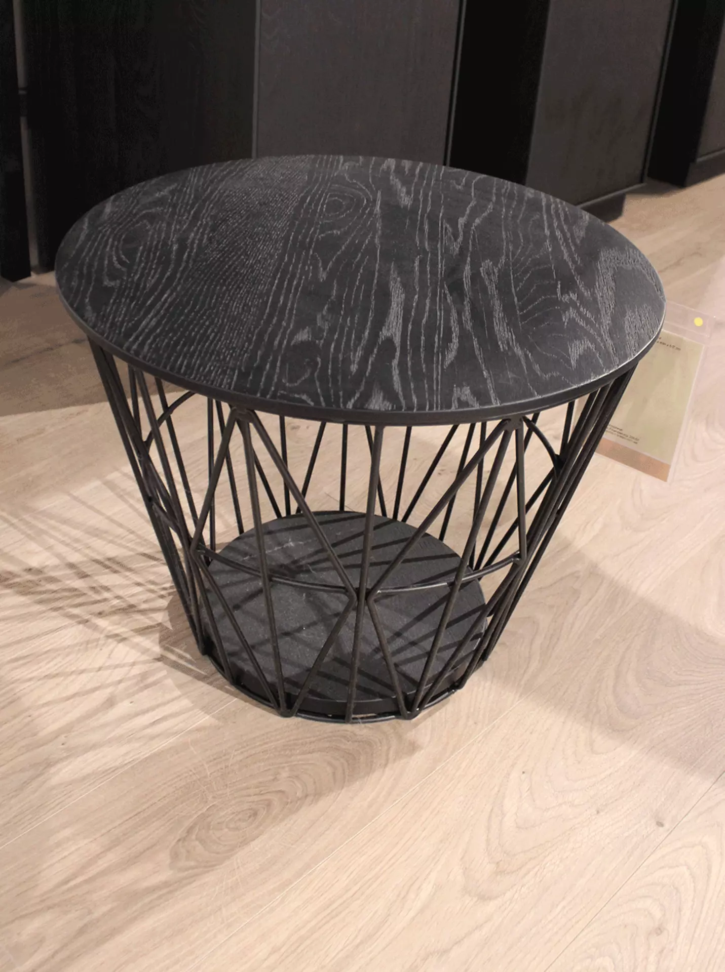 Ein Bild von einem Ausstellungsstück das einen kleinen Beistelltisch in Schwarz zeigt 