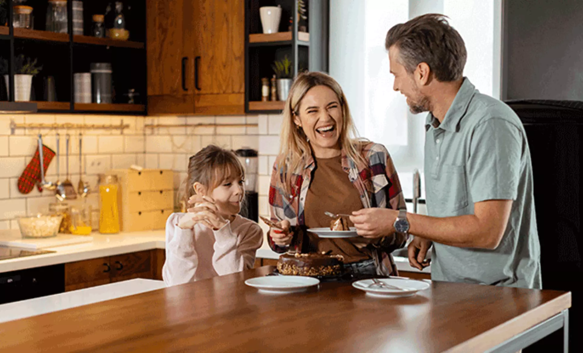 ein Bild von einer kleinen Familie die zusammen in der Küche Kuchen essen in den Maßen 660x400px