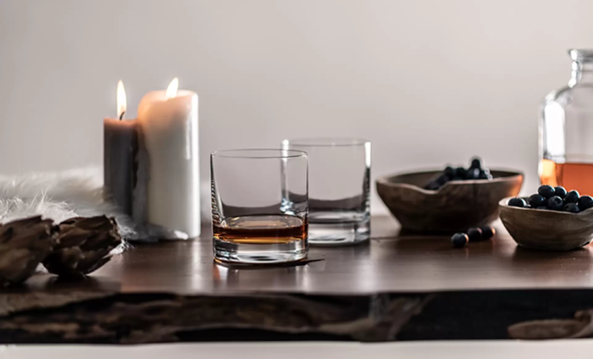 Whiskeygläser der Marke Zwiesel auf einem schönen Holztisch mit Kerzen und Dekoration