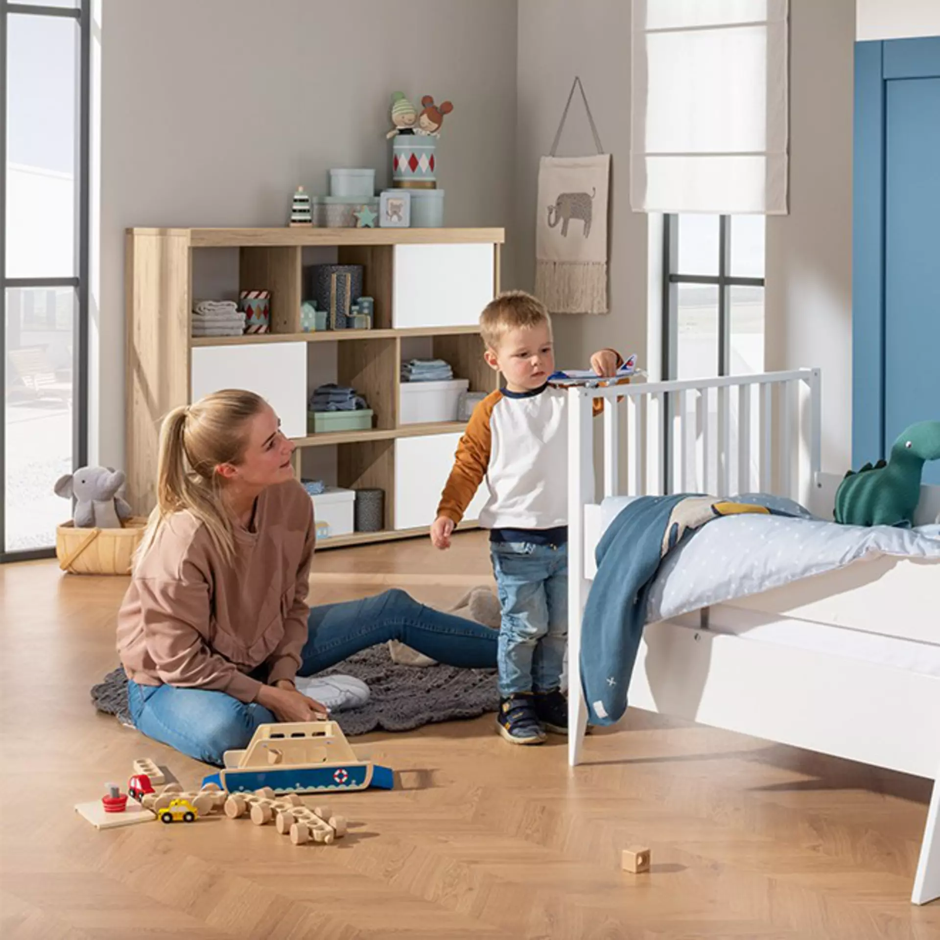 Mutter und Sohn im Kinderzimmer, während der Sohn spielt