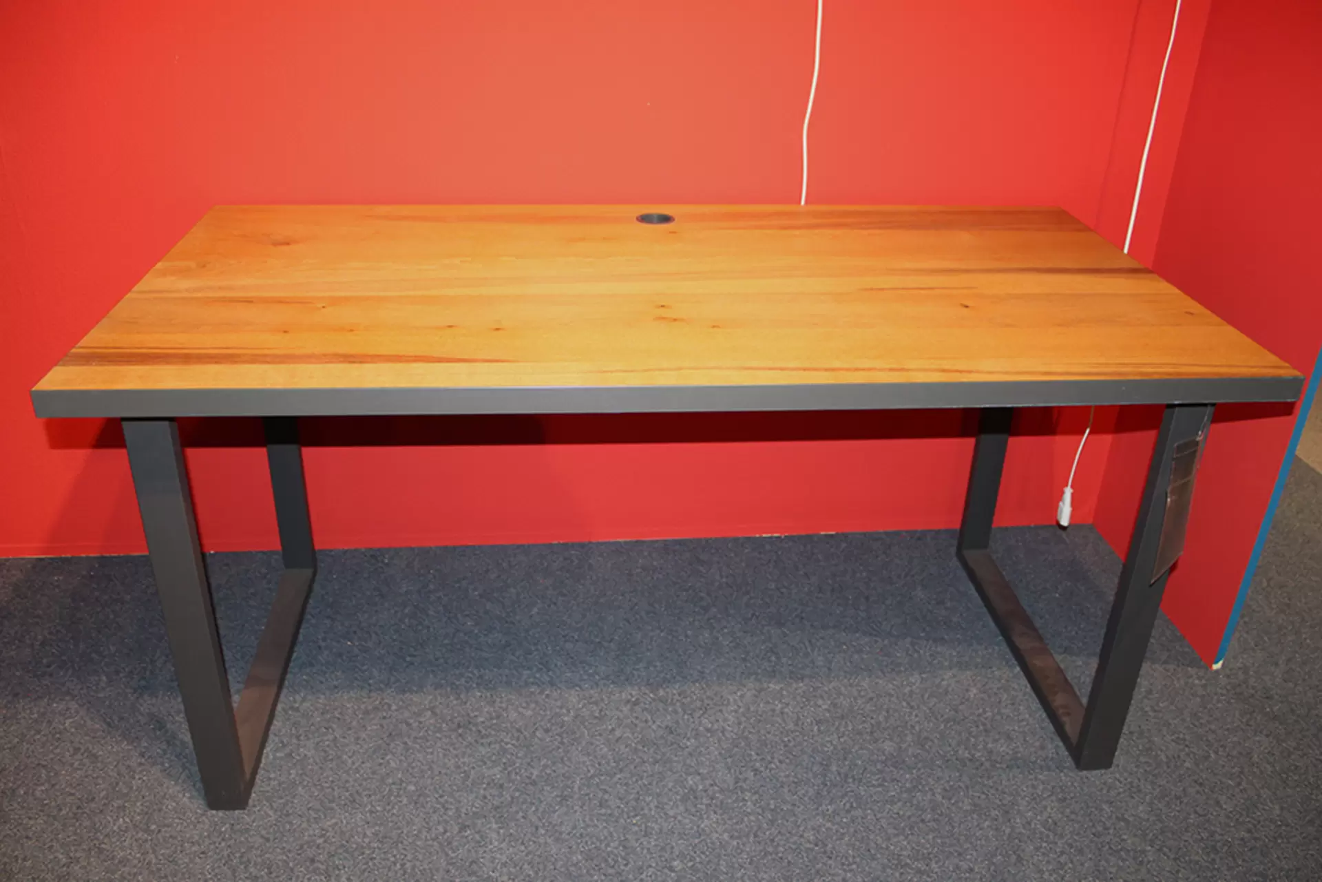 Ein Schreibtisch mit massiver Holzplatte und Metallbeinen von CELECT