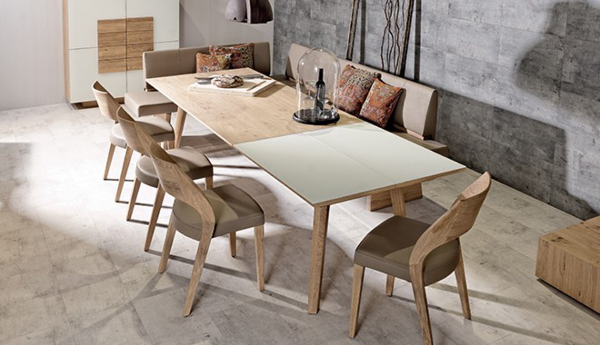 Ausziehbarer Esstisch aus hellem Holz, dazu Esszimmerstühle ohne Armlehne. von Möbel Inhofer.