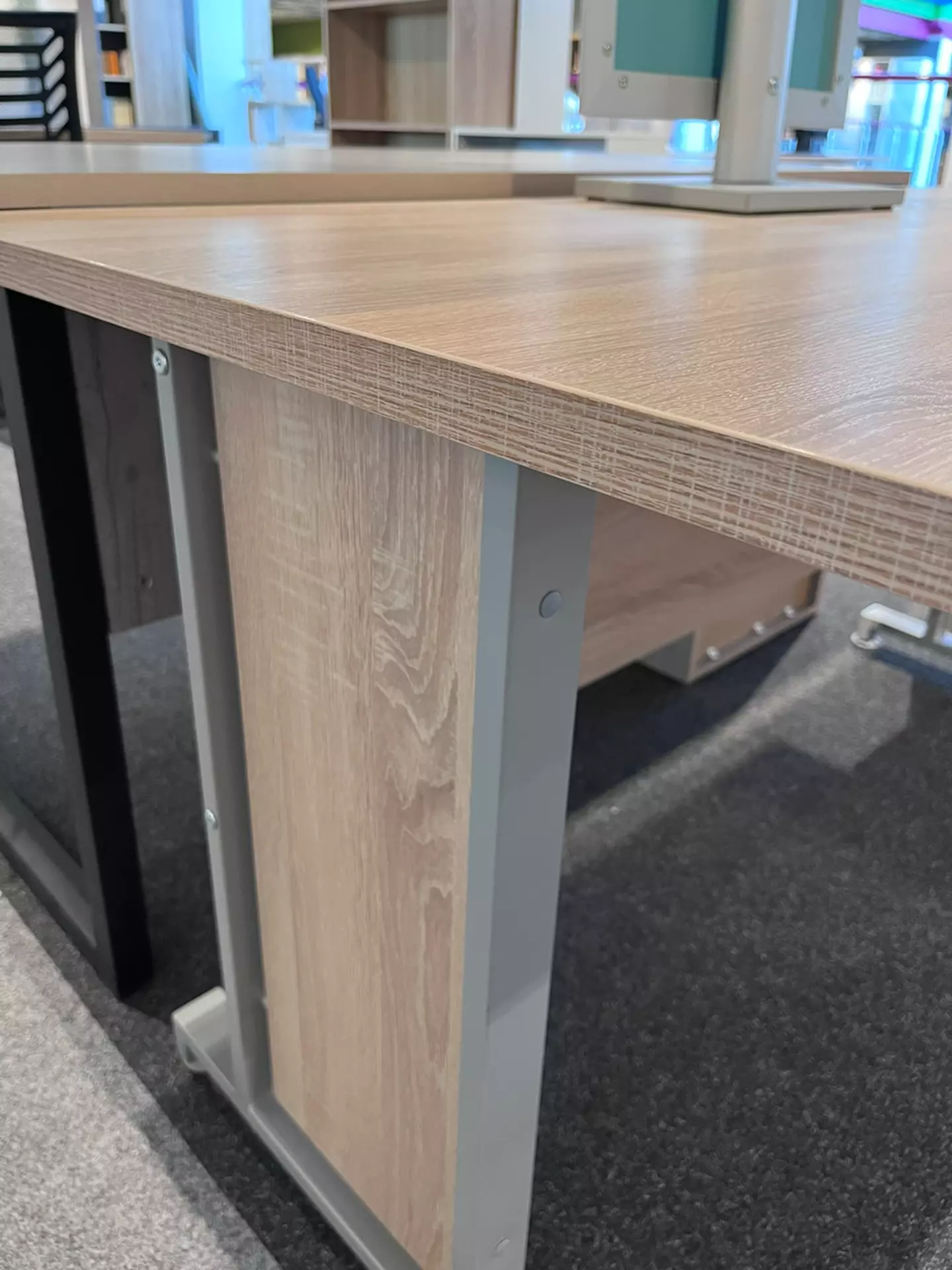 Eine Kante von einem Schreibtisch der Marke Composad wo man sehen kann aus welchem Material es hergestellt wurde