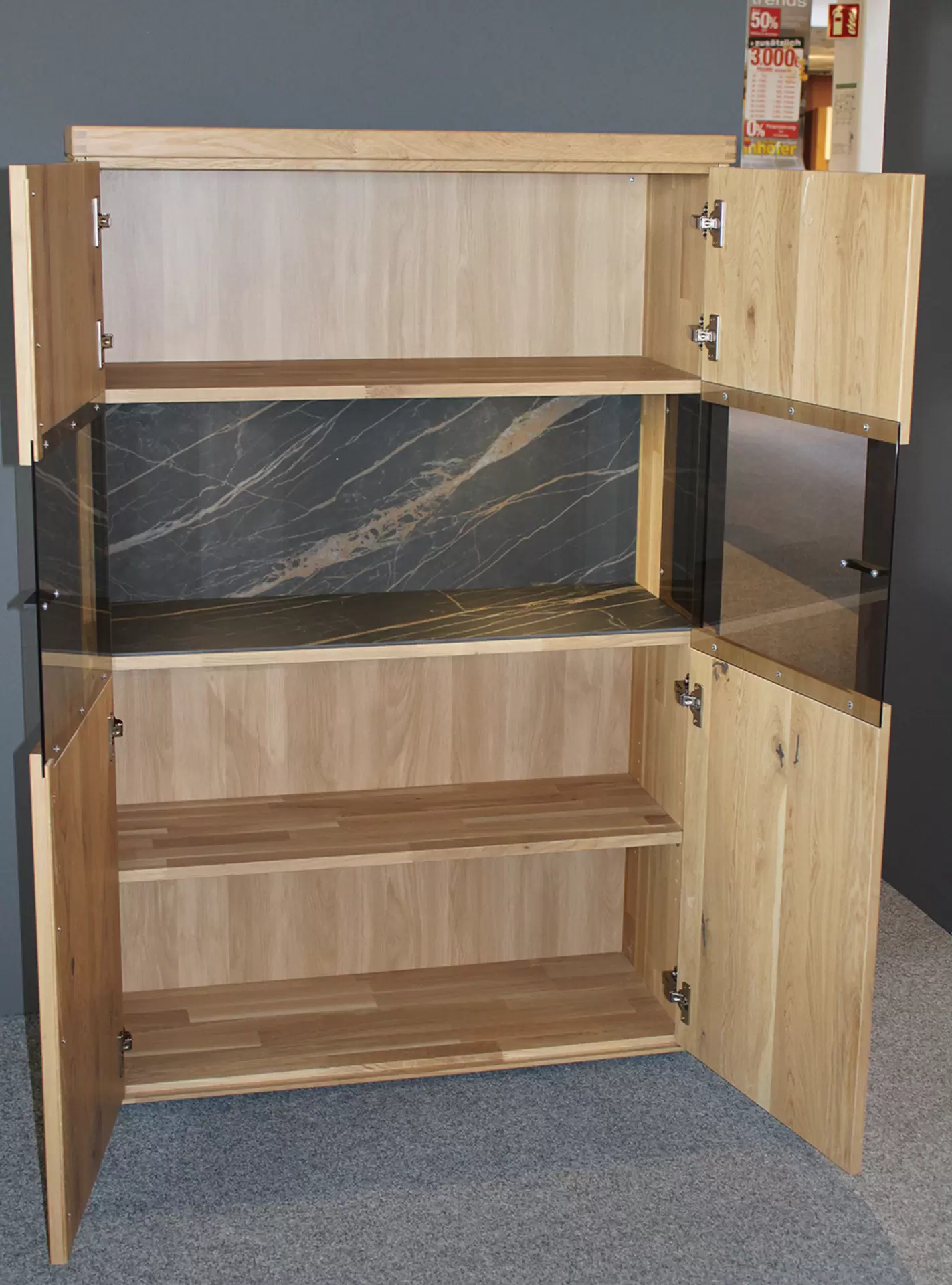 Das Highboard TIRANO von Wöstmann aus massivem Holz miz Glaselementen