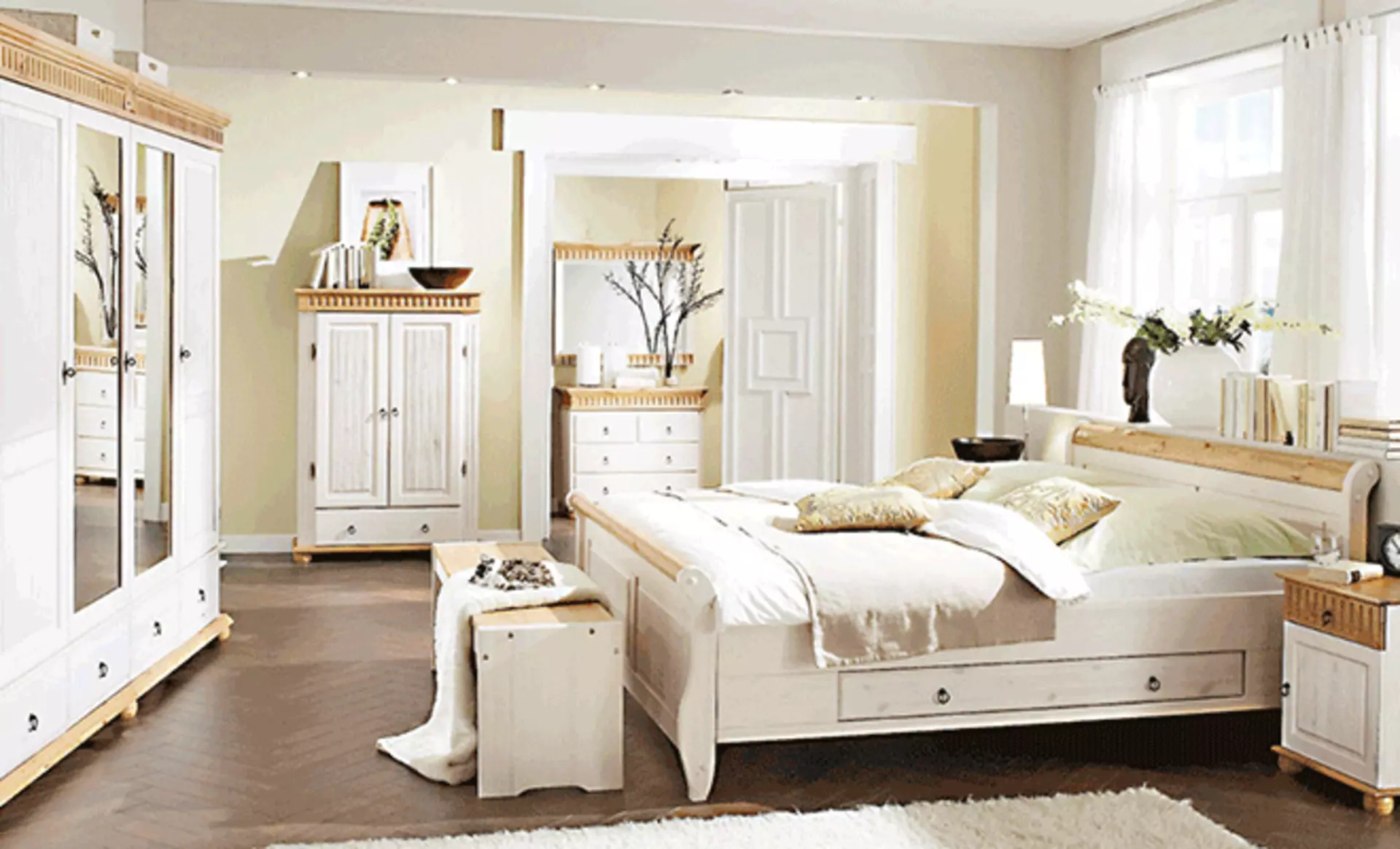 Schlafzimmer im Landhausstil zeigt großes Bett und breiten Kleiderschrank.- Die Möbel sind aus Holz, dabei sind einige Elemente naturbelassen, der Großteil jedoch weiß lasiert.