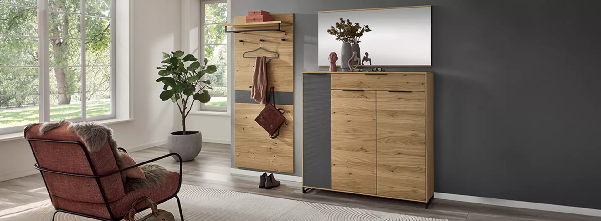 Garderobe aus holz die aus einem garderobenpaneel besteht und einer Kommode die vor einer dunkel grauen wand stehen 