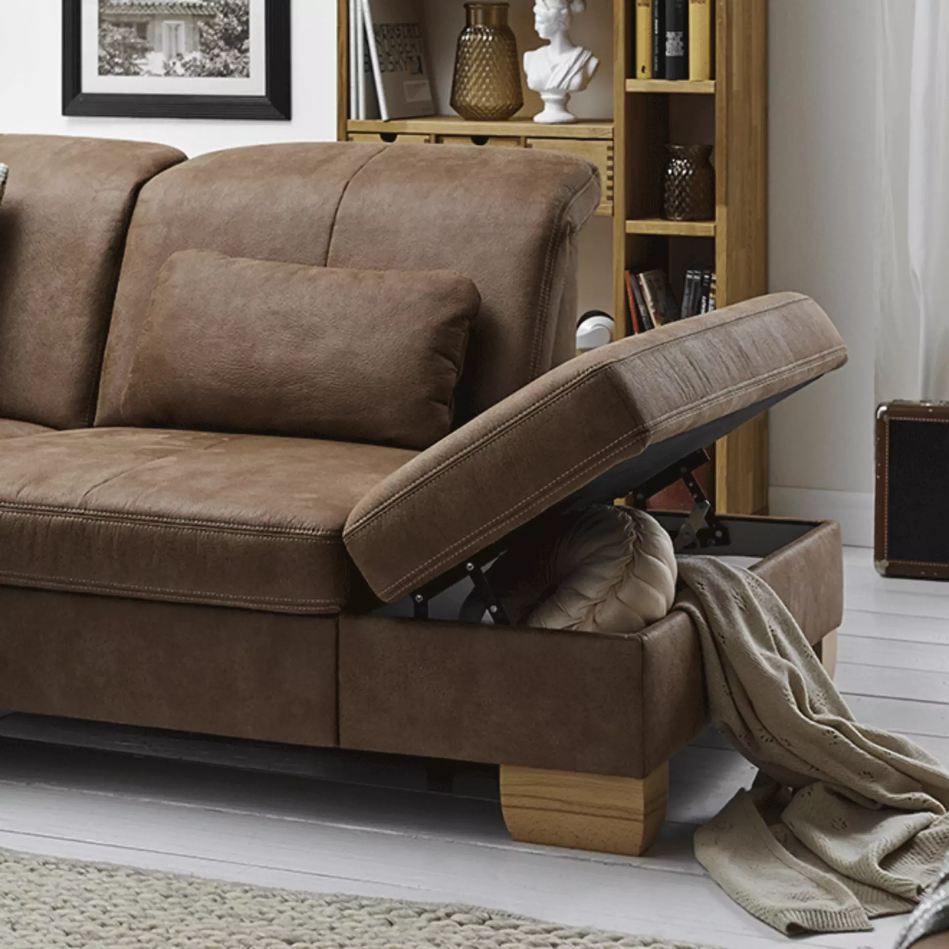Braunes Sofa mit aufgeklappter Stauraumfunktion