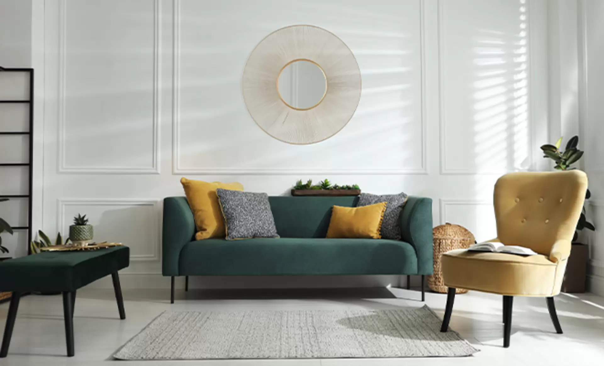 Ein runder Spiegel von Mirrors and More mit dickem Rahmen in Gold der an einer Wand in einem Wohnzimmer mit blauem Sofa hängt