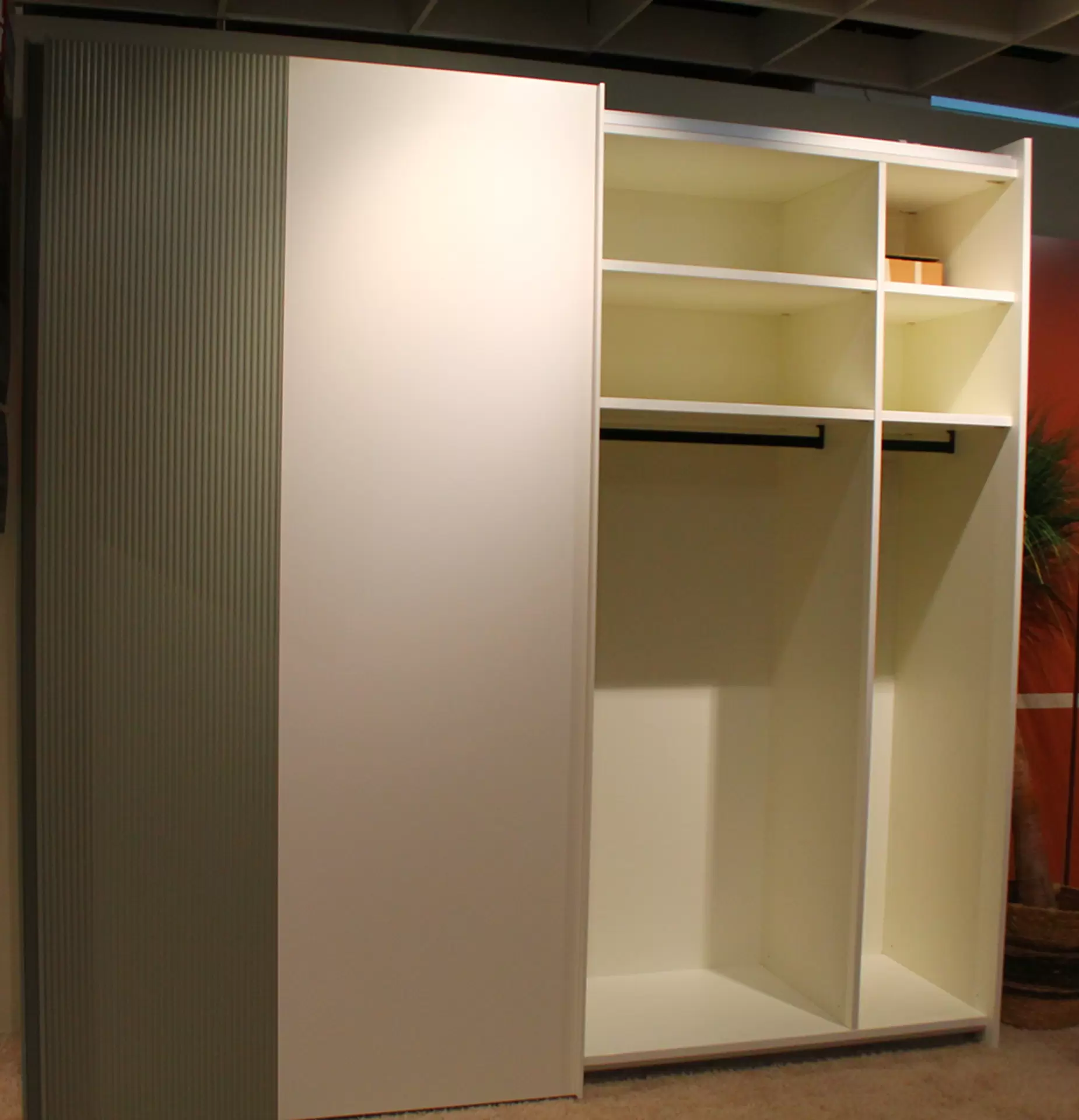 Ein Schwebetürenschrank von Sudbrock in weiß und Salbei lackiert