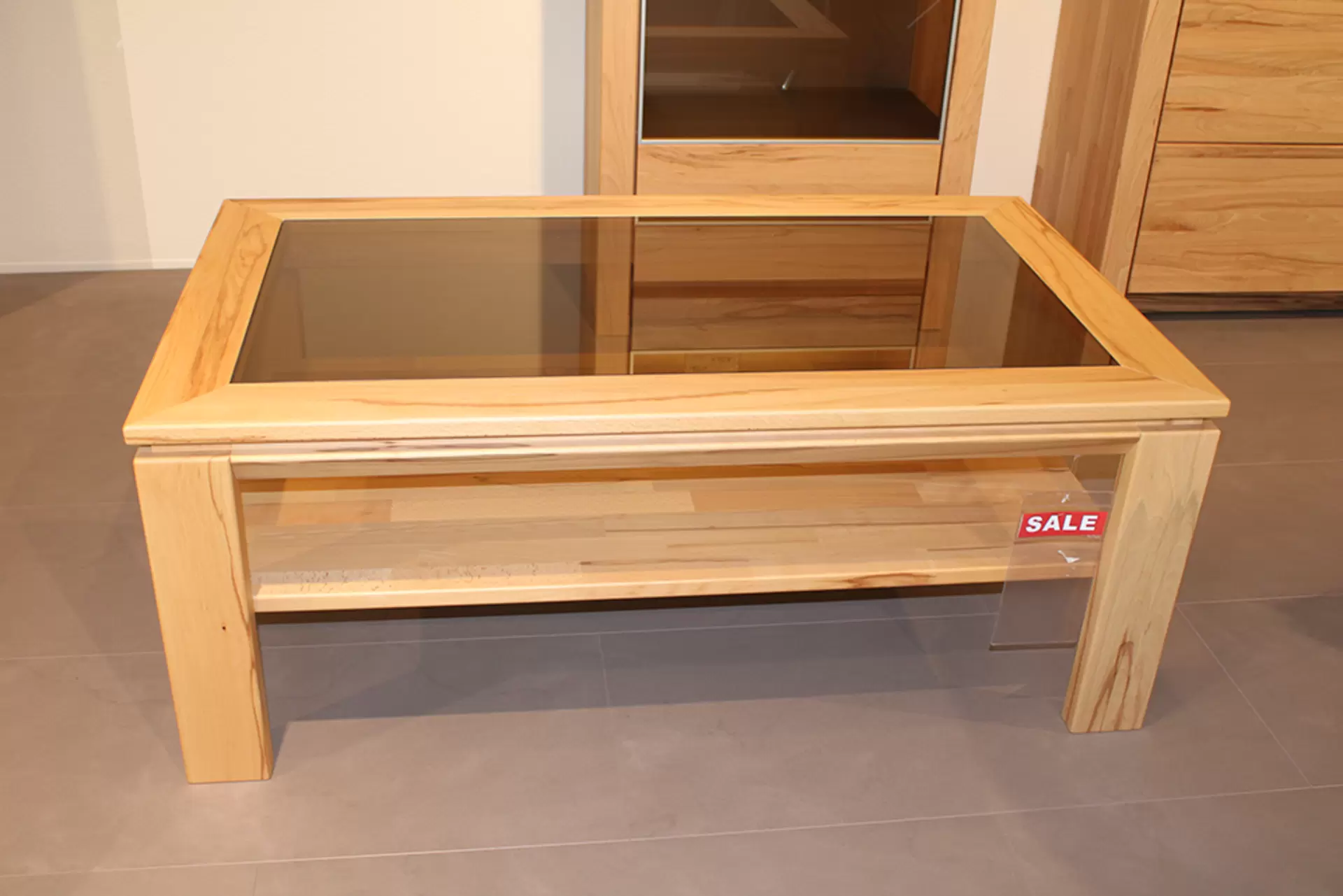 Der Couchtisch SORAGA von Wöstmann aus massivem Holz mit Glasplatte