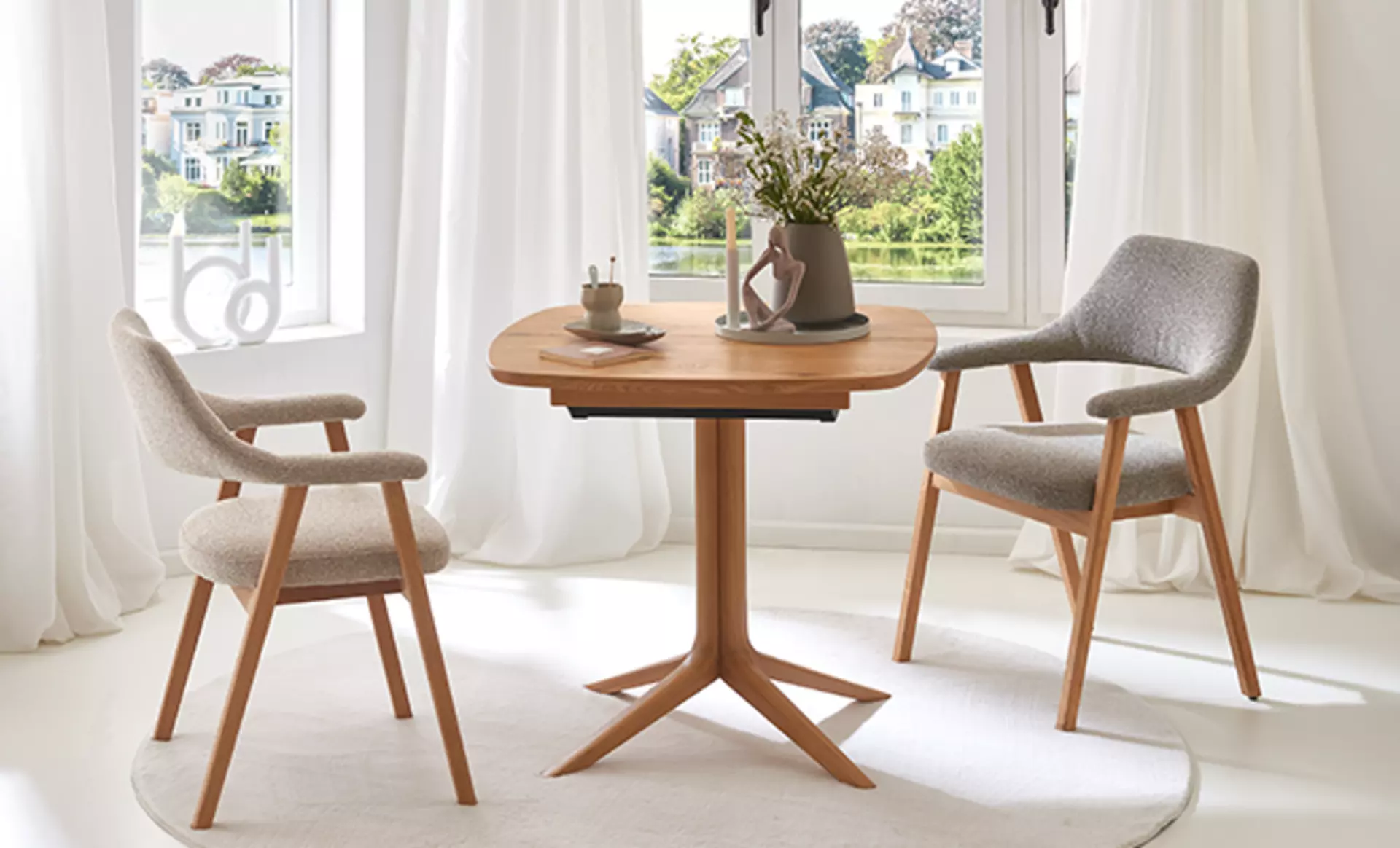 Esszimmertisch aus Holz mit zwei grauen Stühlen