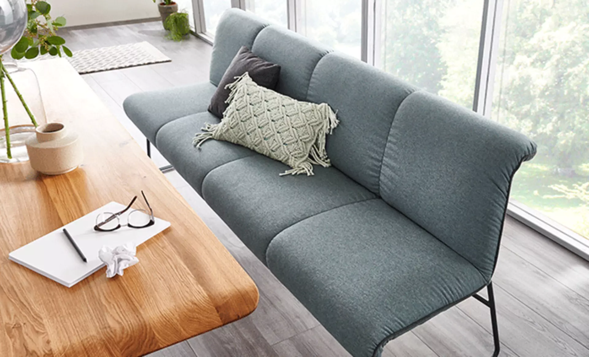 Sitzbank in grauer Farbe an einem Holztisch im Esszimmer