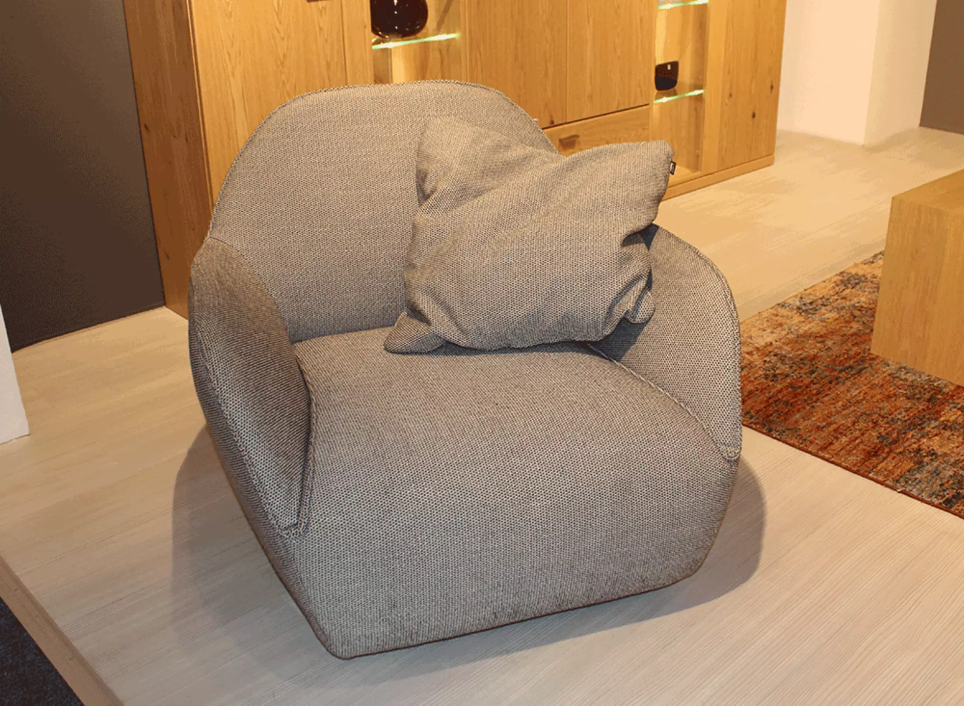 Ein Grauer Sessel mit kleinem Kissen inklusive als Abverkaufsstück