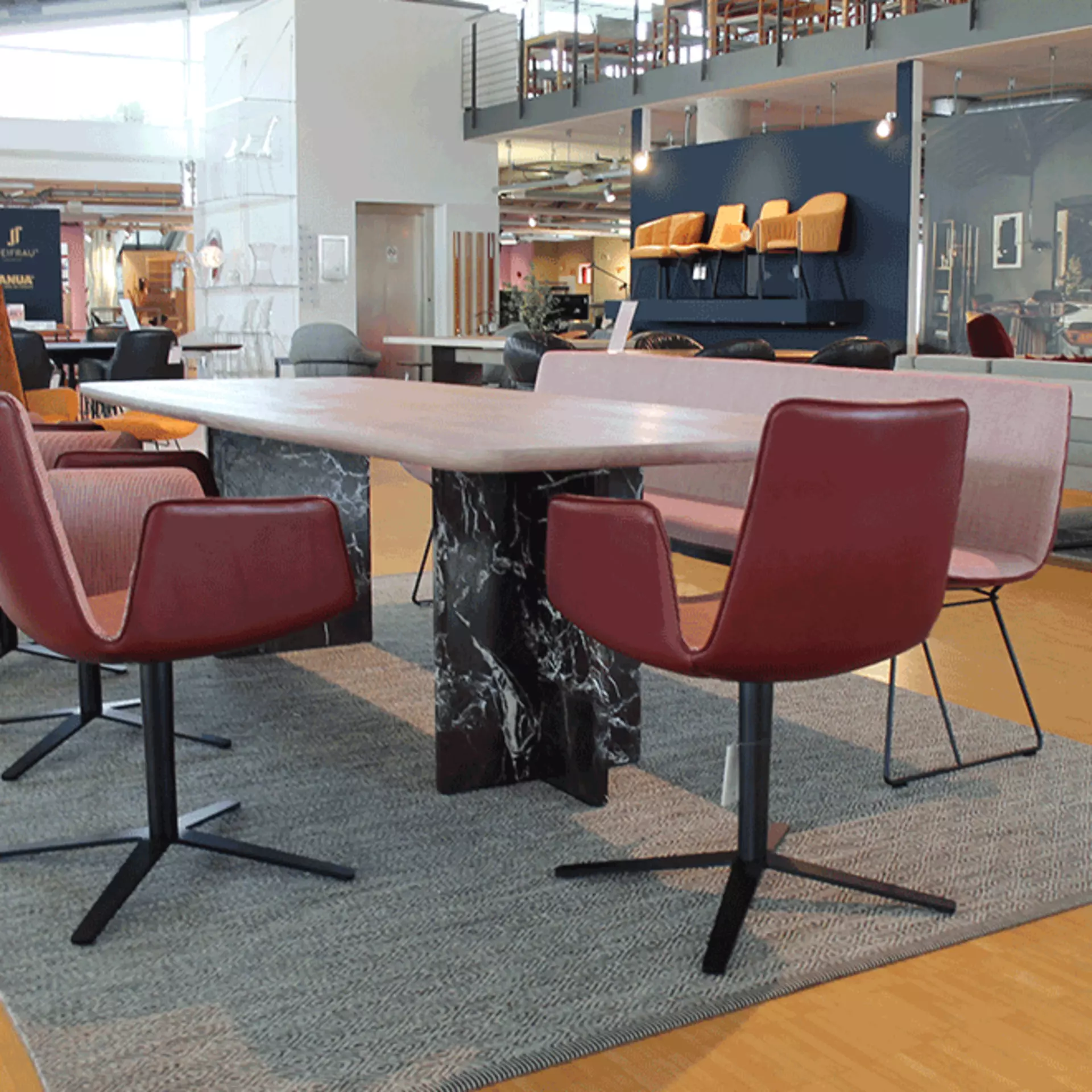 Janua Editionstisch mit Designerstühlen und Sitzbank von Freifrau in der Ausführung Amelie Variante Bend Keder Leder Adora berry