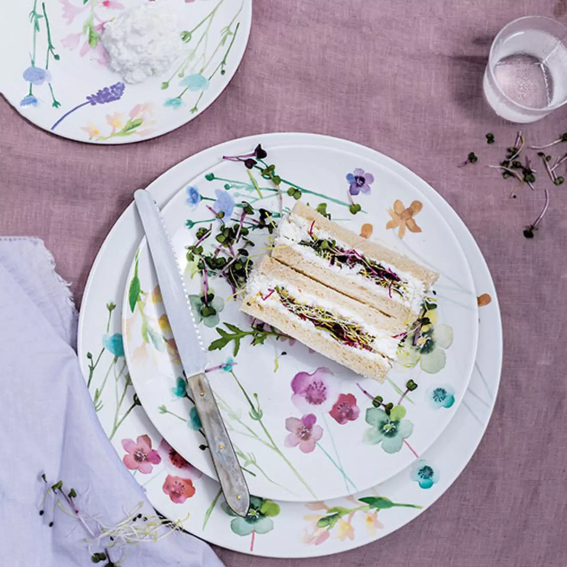 Auf dem Teller liegt ein Kuchen der aufgeschnitten wurde. Neben dem Kuchen liegt ein Messer 