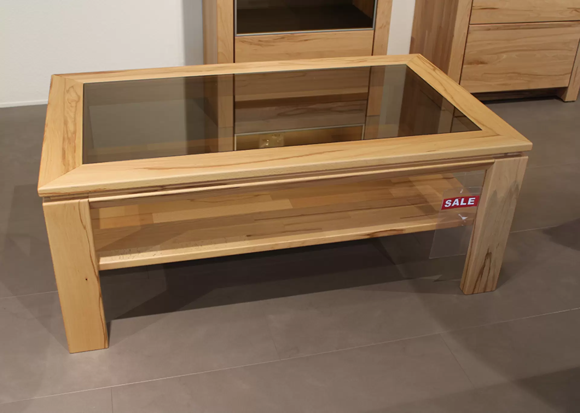 Der Couchtisch SORAGA von Wöstmann aus massivem Holz mit Glasplatte
