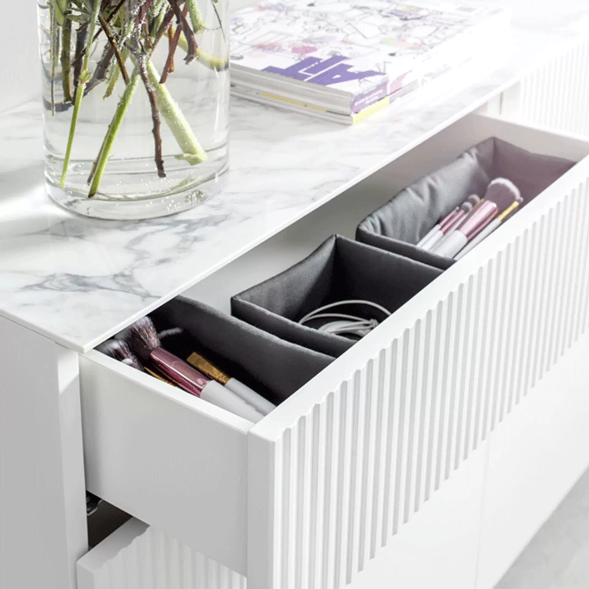 Offene Schublade einer Schminkkonsole mit praktischen Stoff-Organizern für Kosmetik, Pinsel und Make-up-Utensilien