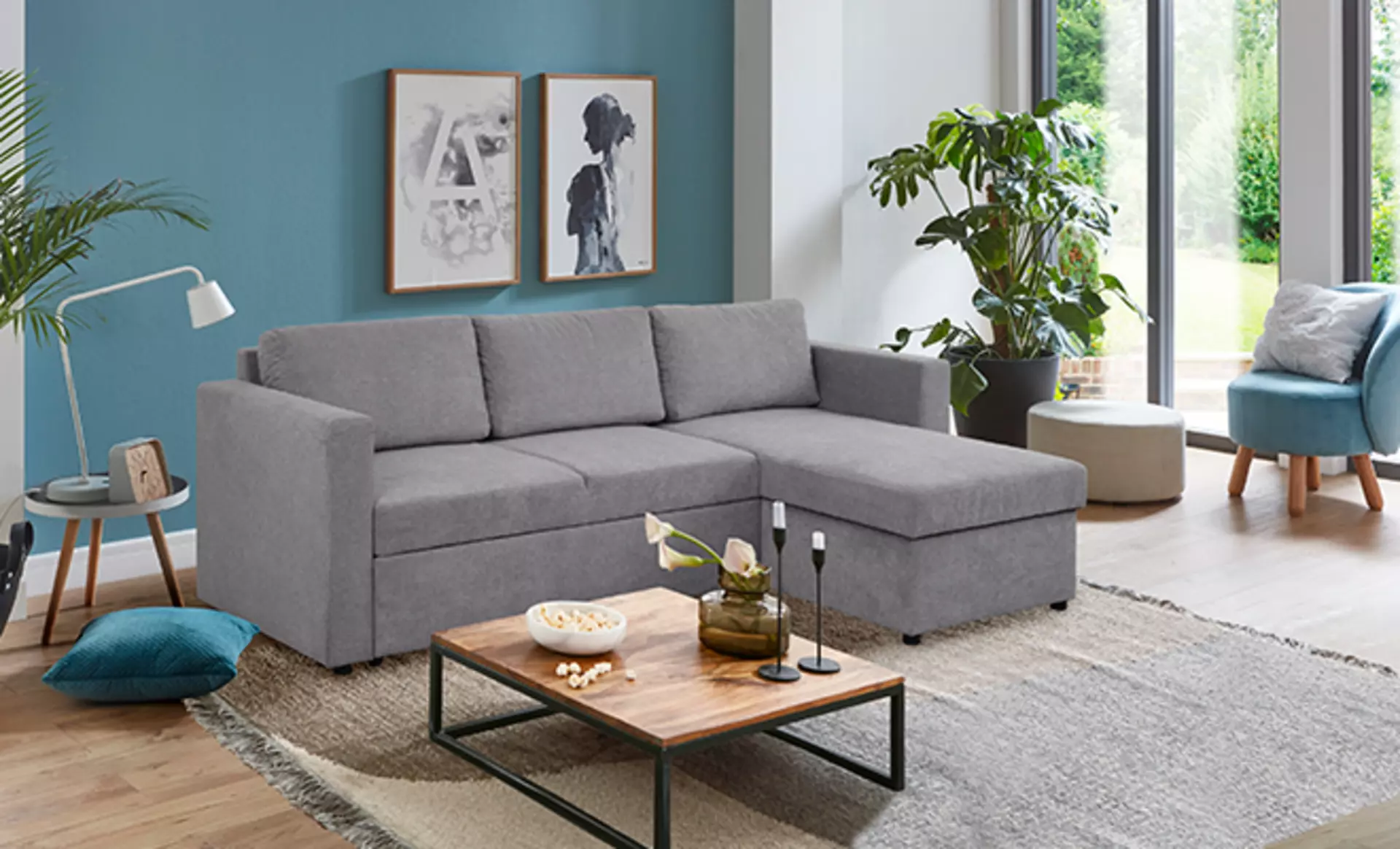 Kompakte graue Wohnlandschaft mit schickekm Wohnzimmertisch und Cocktailsessel in kleinem Wohnzimmer