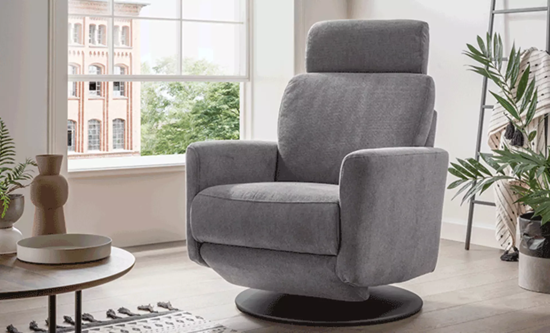 Grauer Stoff-Sessel in einem kleinen, modern eingerichteten Wohnzimmer