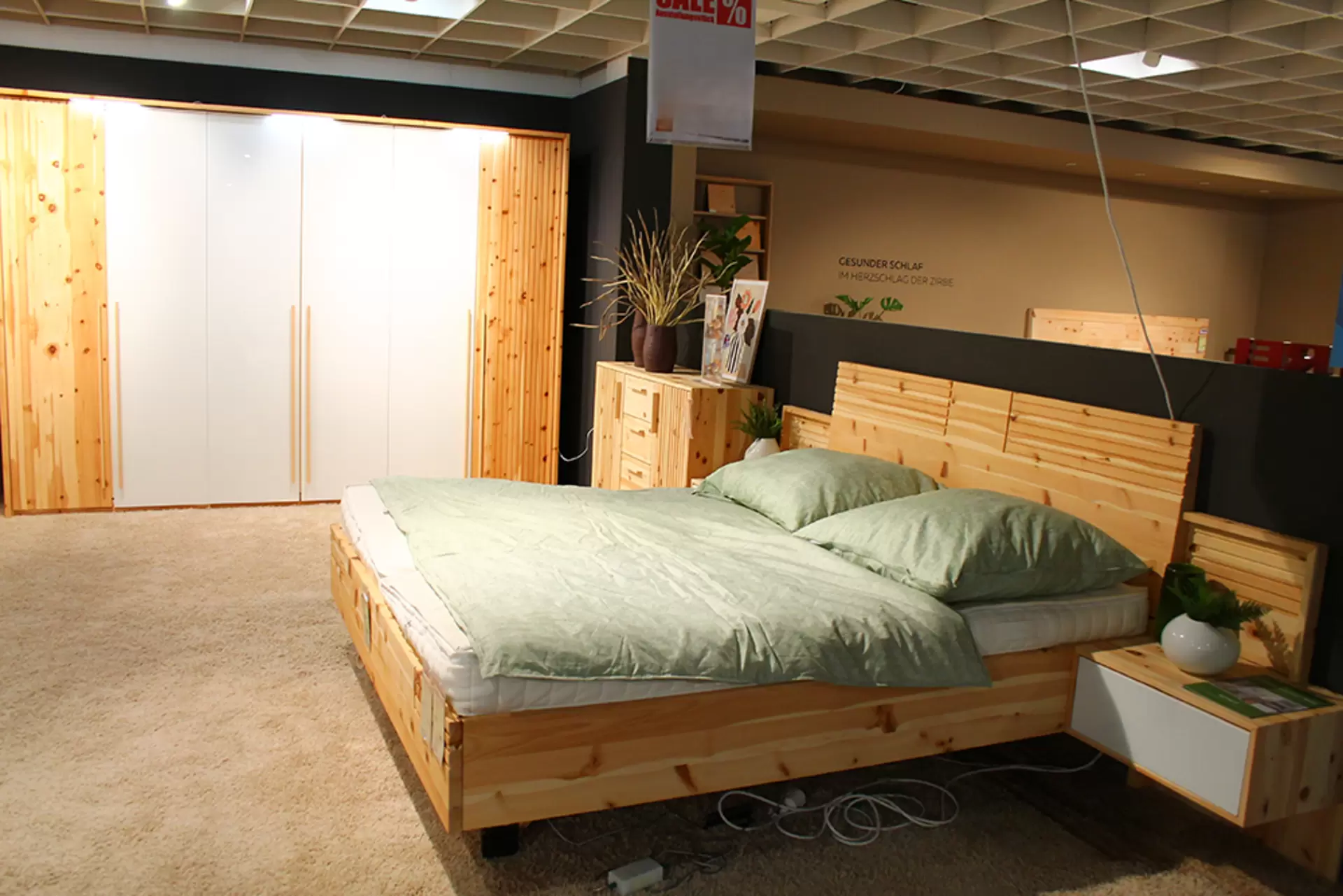 Ein Schlafzimmer von Lip Phistvo aus zirbe massiv mit Bett, Kommode und Schrank mit weißen Lackelementen