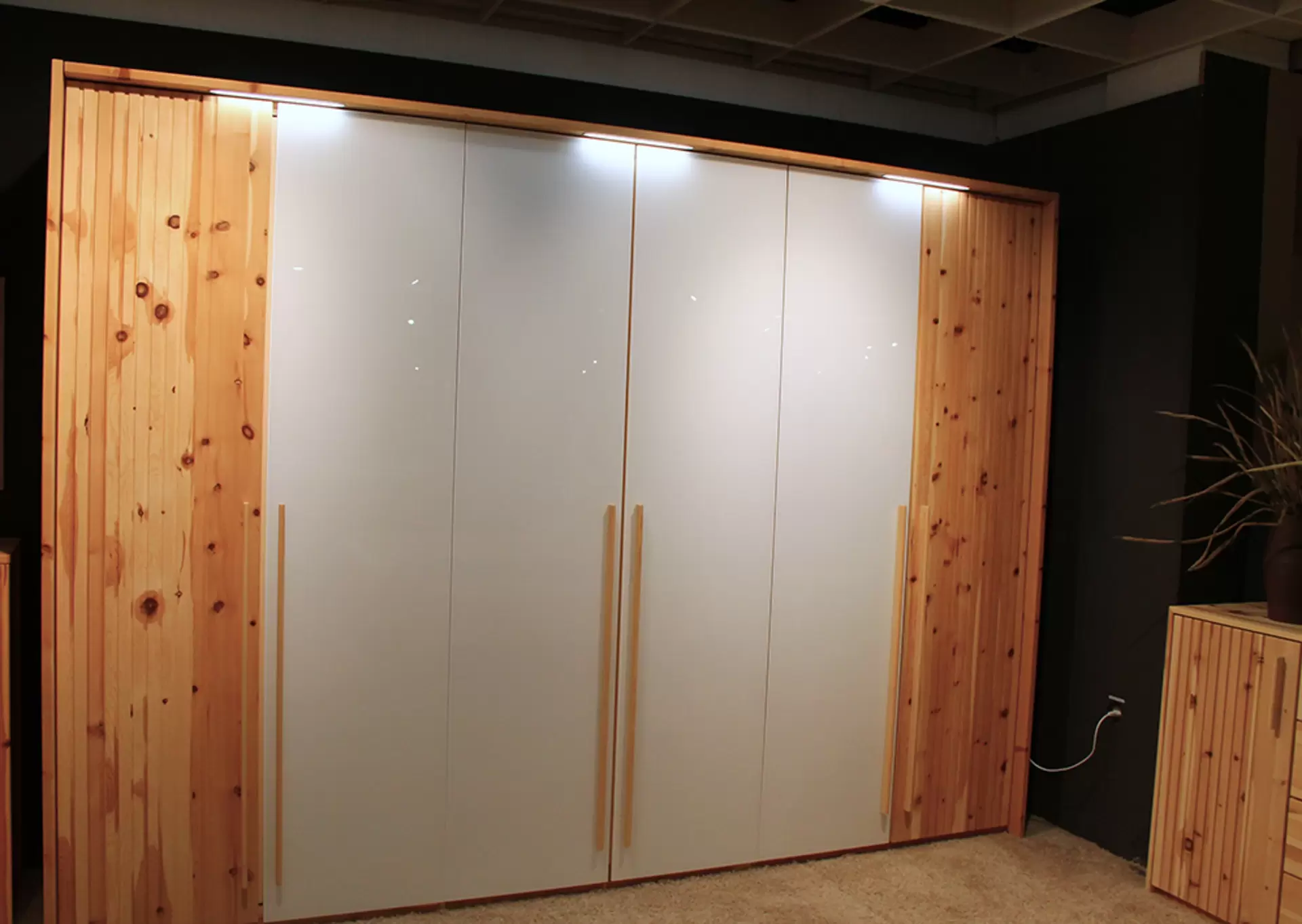 Ein Schlafzimmer von Lip Phistvo aus zirbe massiv mit Bett, Kommode und Schrank mit weißen Lackelementen