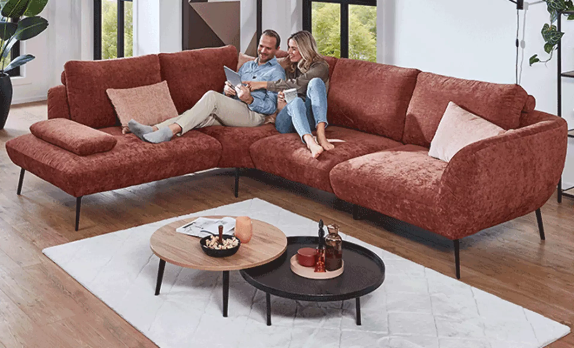 Paar im Wohnzimmer mit modernen Satz-Tischen aus Holz in gemütlicher Wohnatmosphäre