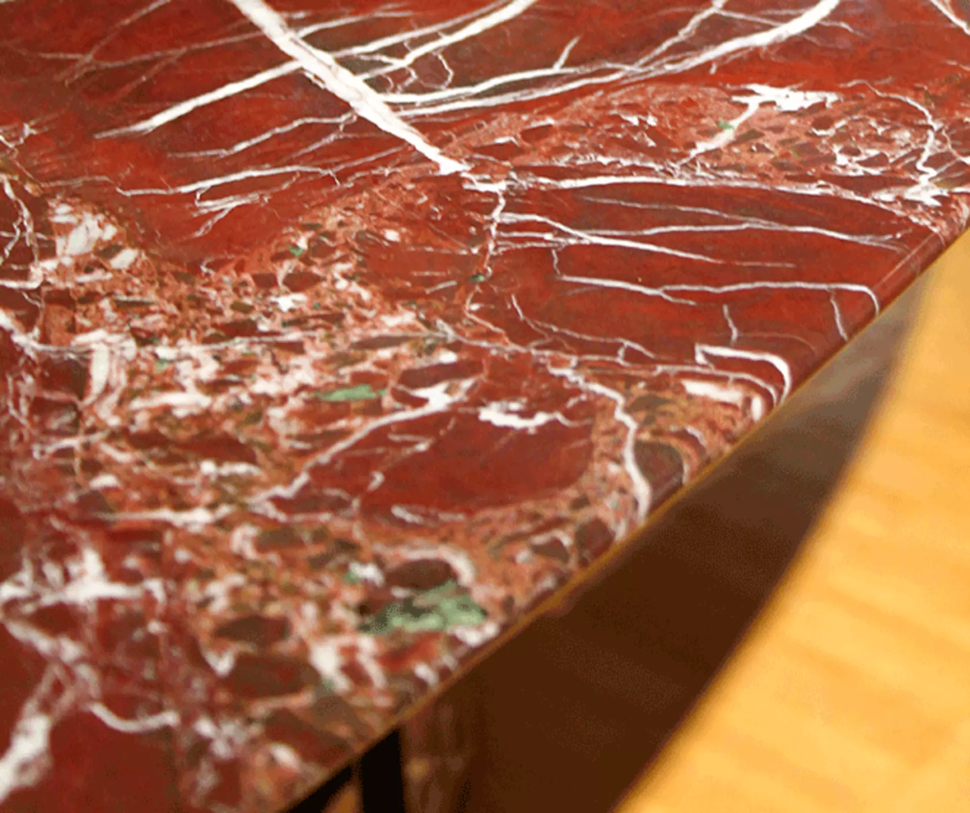 Der rote Marmor des T13 Tisches im Detail