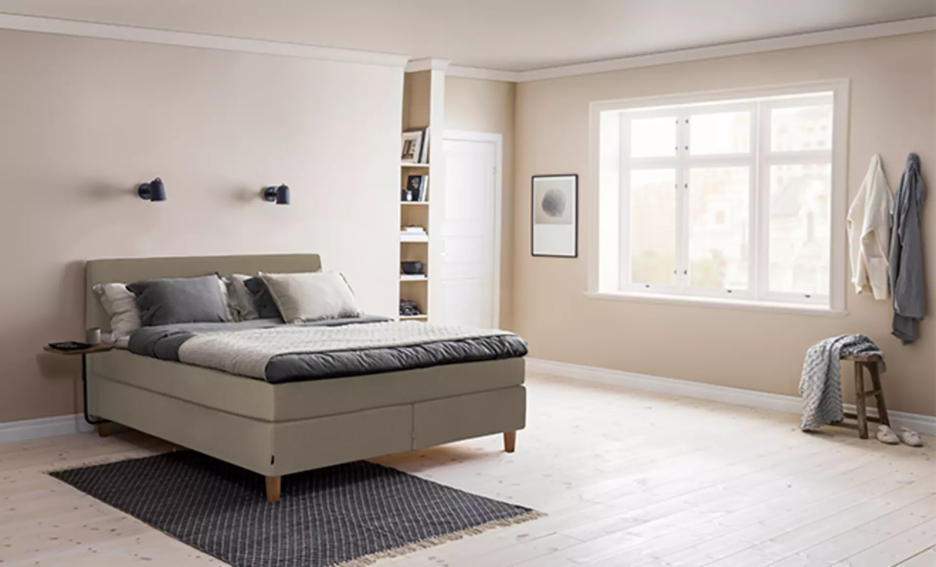 Das Jensen First Continental Boxspringbett in Salbei grau in einem schlichten beige gestrichenen Schlafzimmer