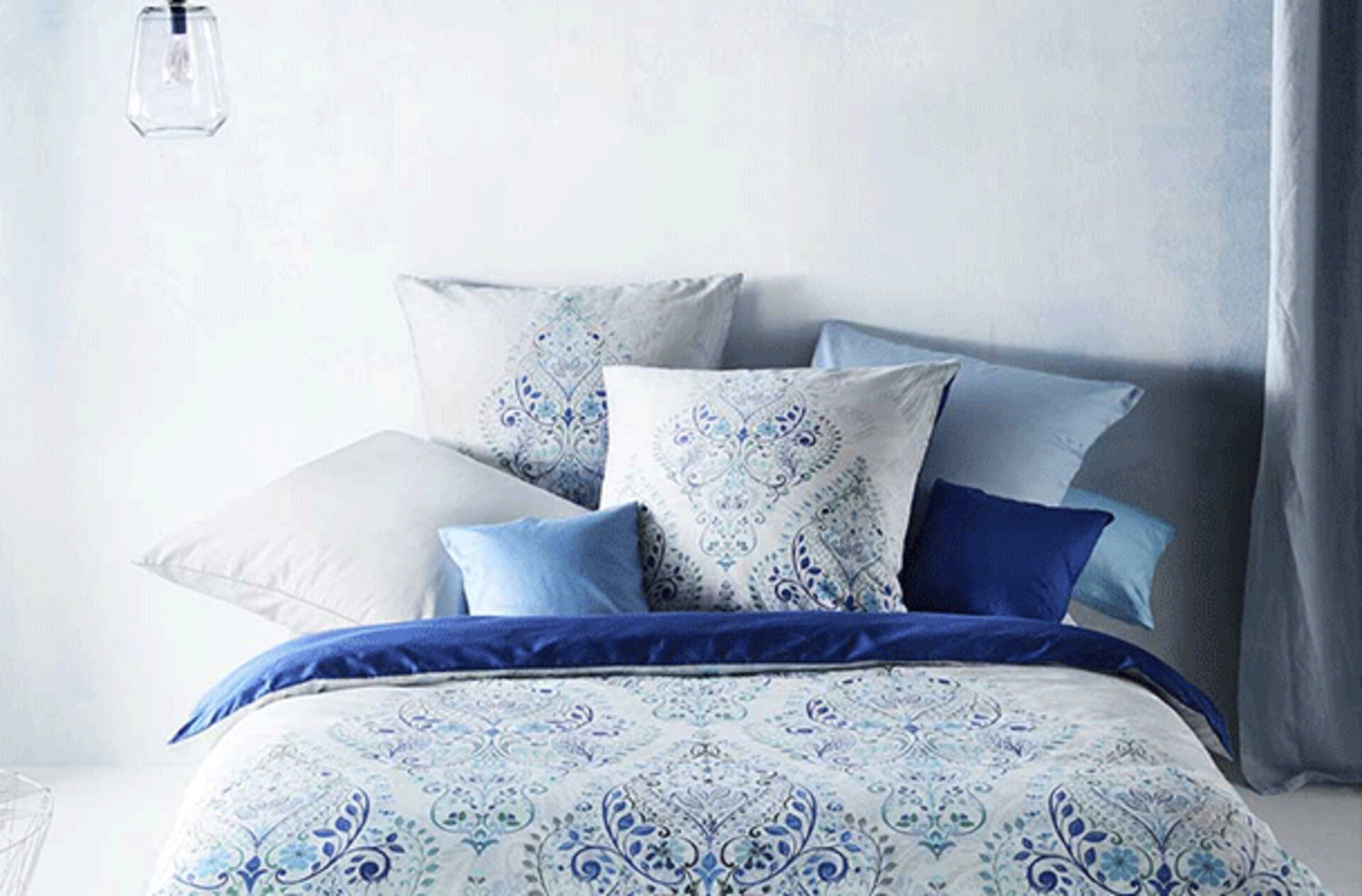 Bettwäsche in Weiß und Blau mit Paisley-Muster.