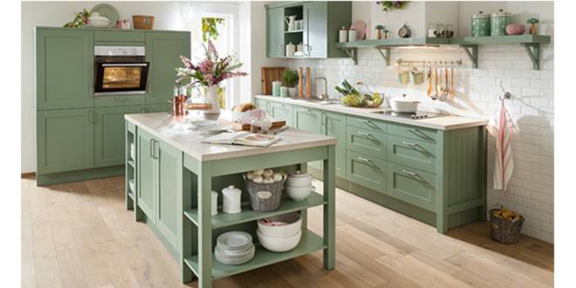 Planungsküche im Landhausstill mit grünen Holzmöbeln und rustikaler Kücheninsel.