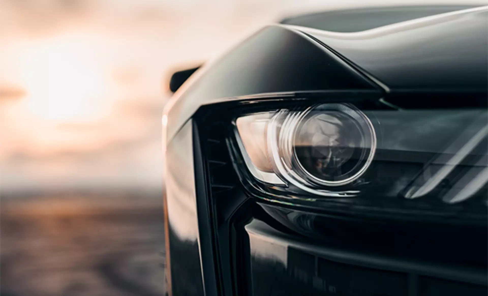Scheinwerfer eines US Musclecars im Sonnenaufgang 