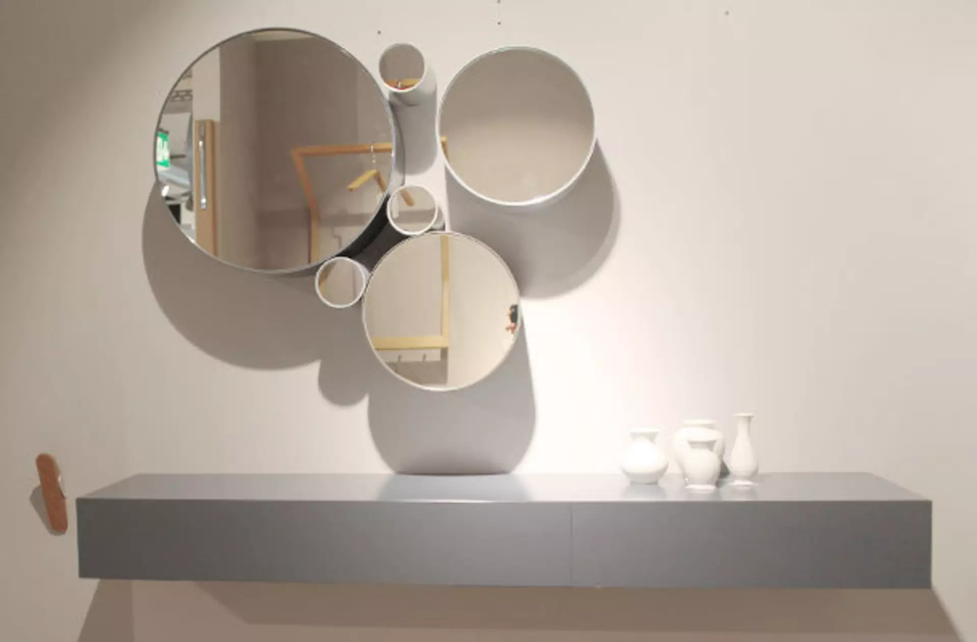 Design-Wandpaneel und eine Spiegelgruppe mit 5 runden Spiegeln