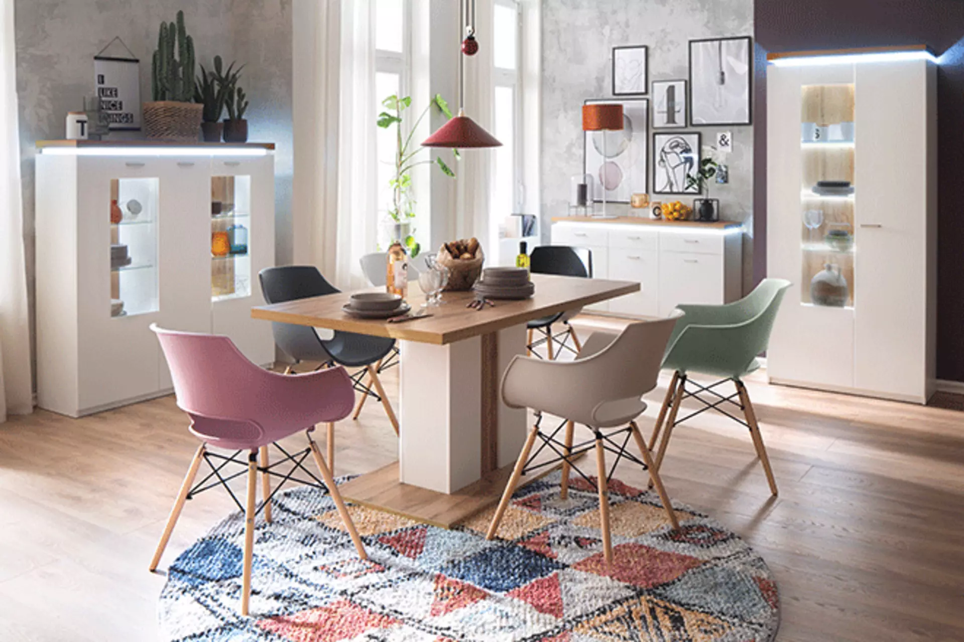 Modernes Esszimmer mit verschieden farbigen Stühlen