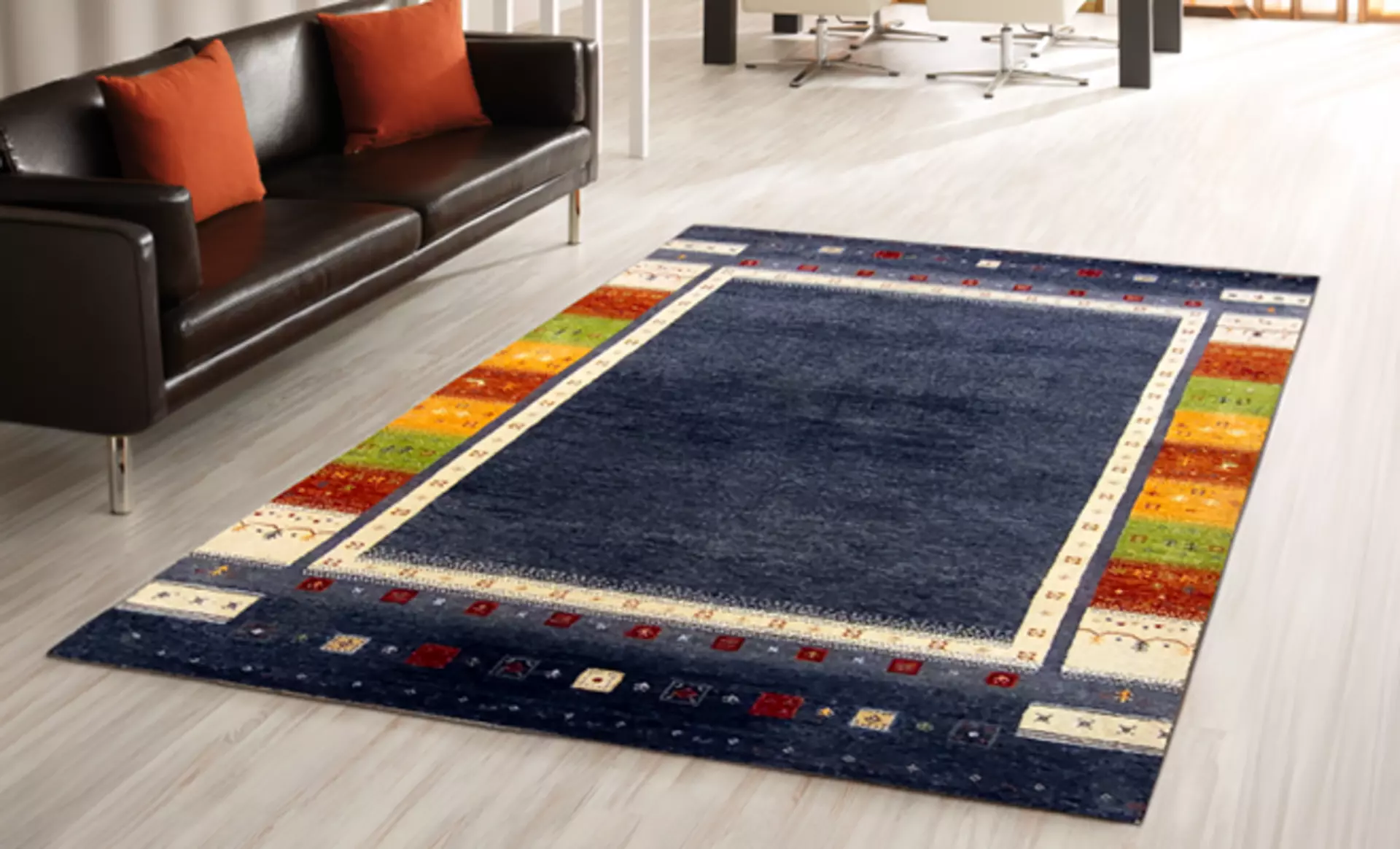 Der Tan Teppich von RUG Studios mit blau roten Stickungen