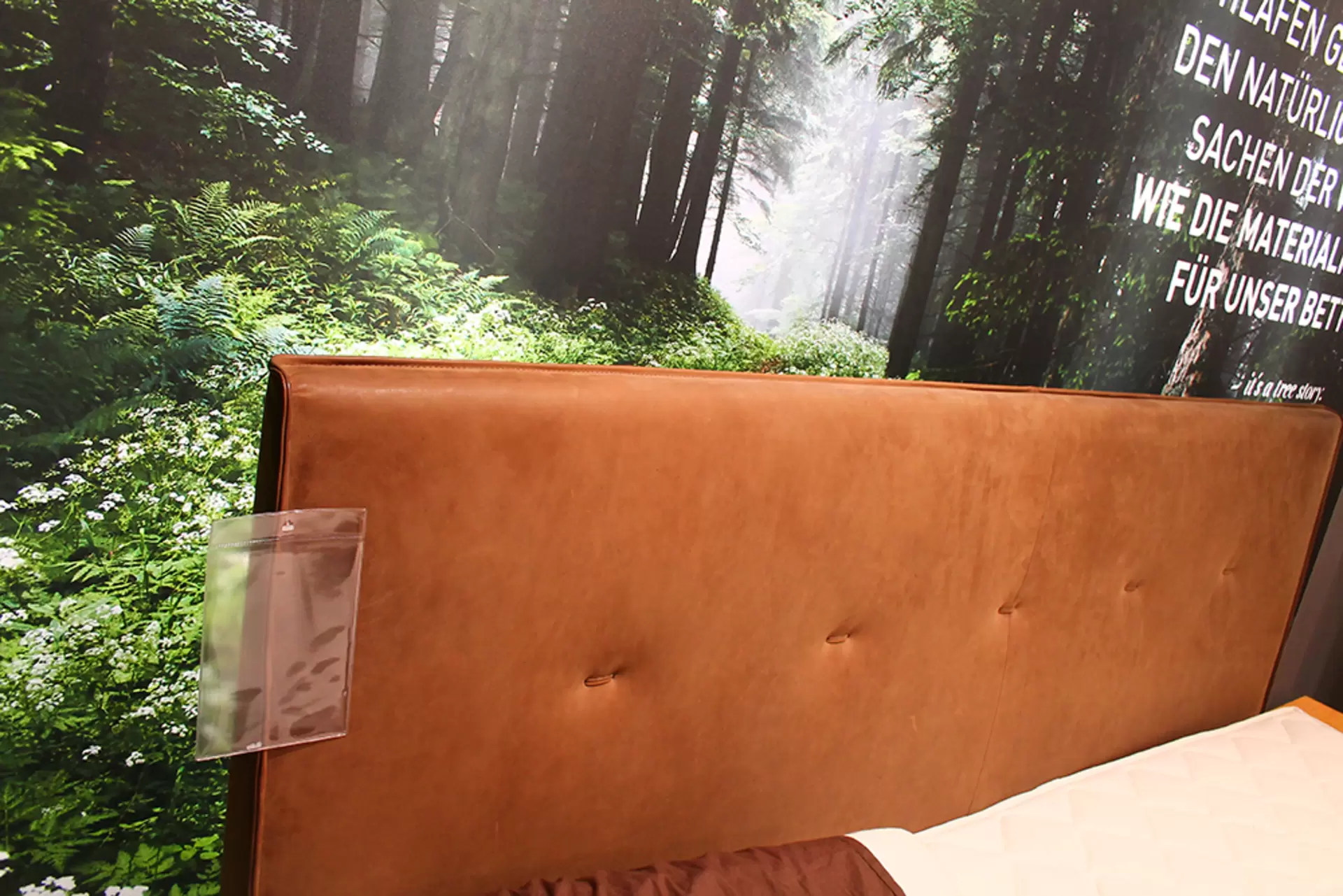 Ein Boxspringbett + Nachtkonsole von Team 7 aus massivem holz und in braunem Stoffbezug