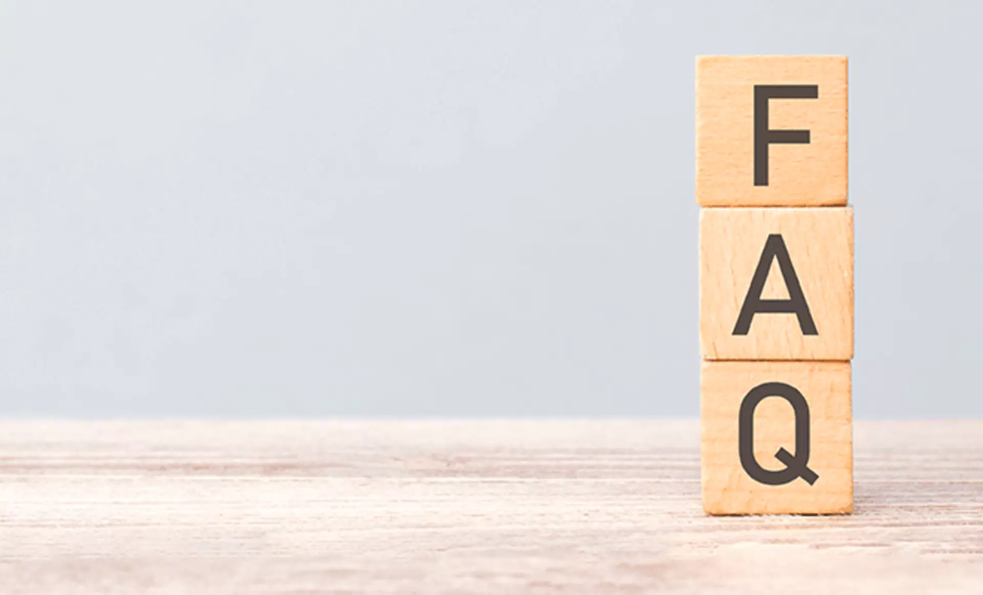 Bild zum FAQ mit schrift auf holzblöcken
