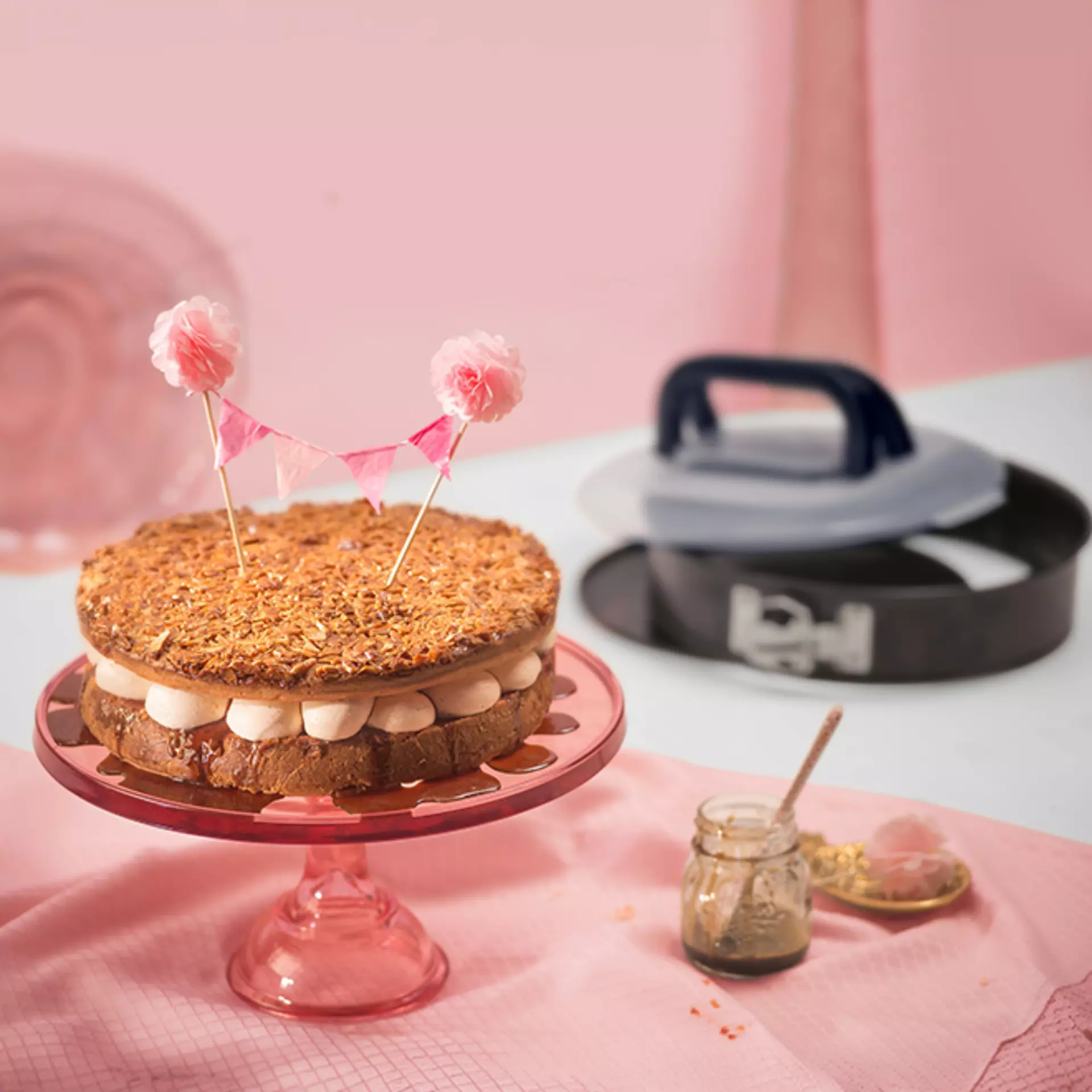 Ein Kuchen auf einer Servierplatte aus rosanem Glas vor einer Kaiser Classic Springform