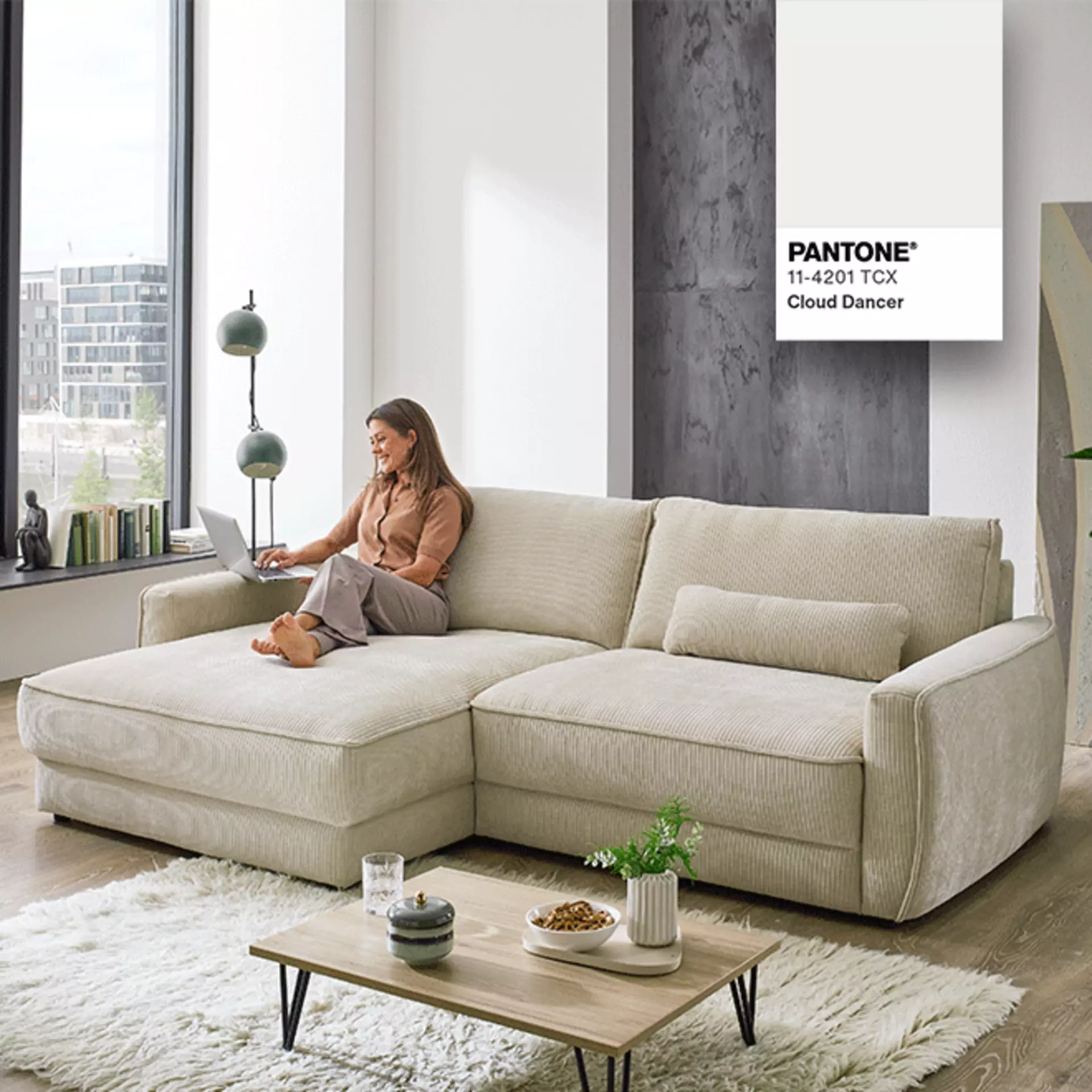 Modern gestalteter Wohnbereich mit Sofa in der Farbe des Jahres „Cloud Dancer“.