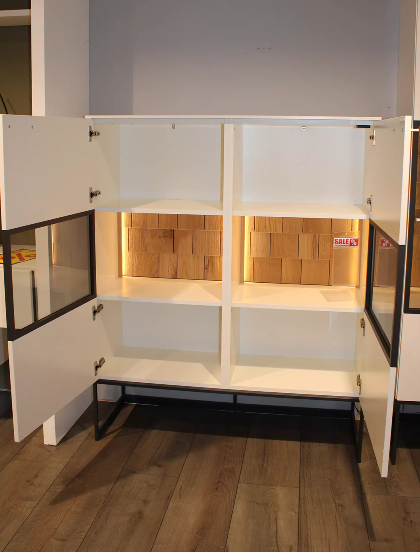 Weißes Highboard mit indirekter Beluchtung und geöffneten Türen