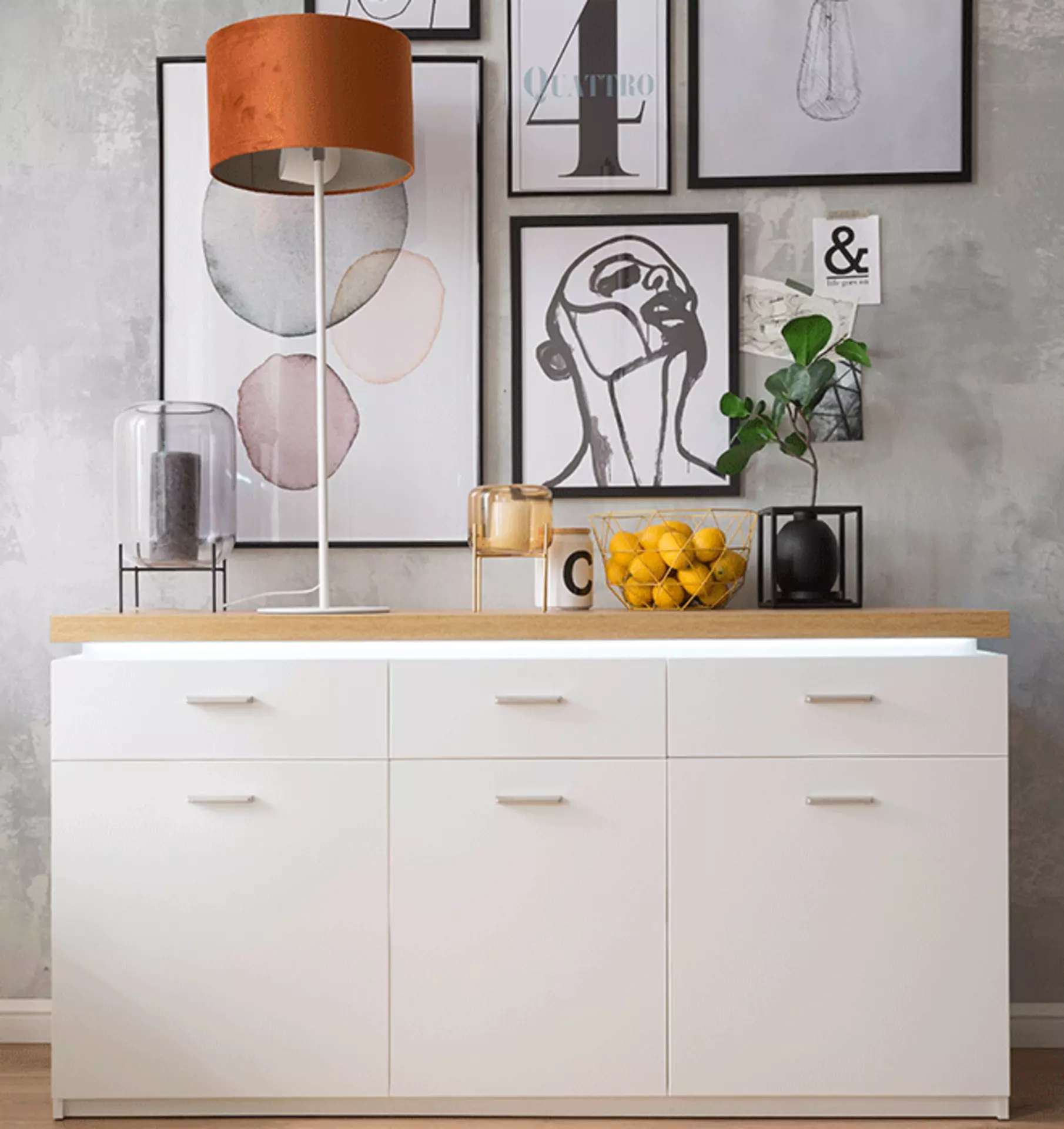 Modernes Sideboard mit Beleuchtung vor Bilderwand
