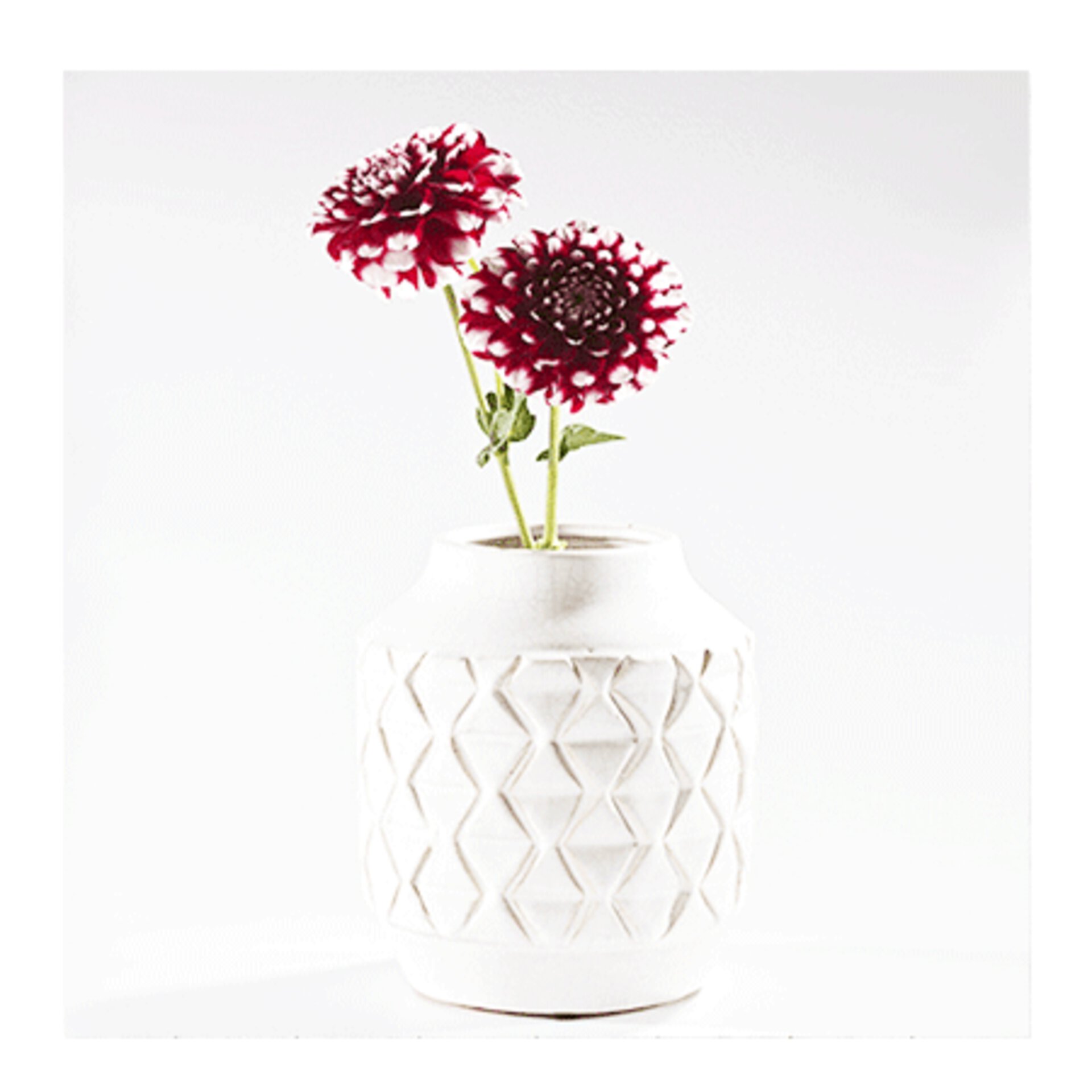 Weiße Ton-Vase in geradliniger Form mit eingearbeitetem Rautenmuster.