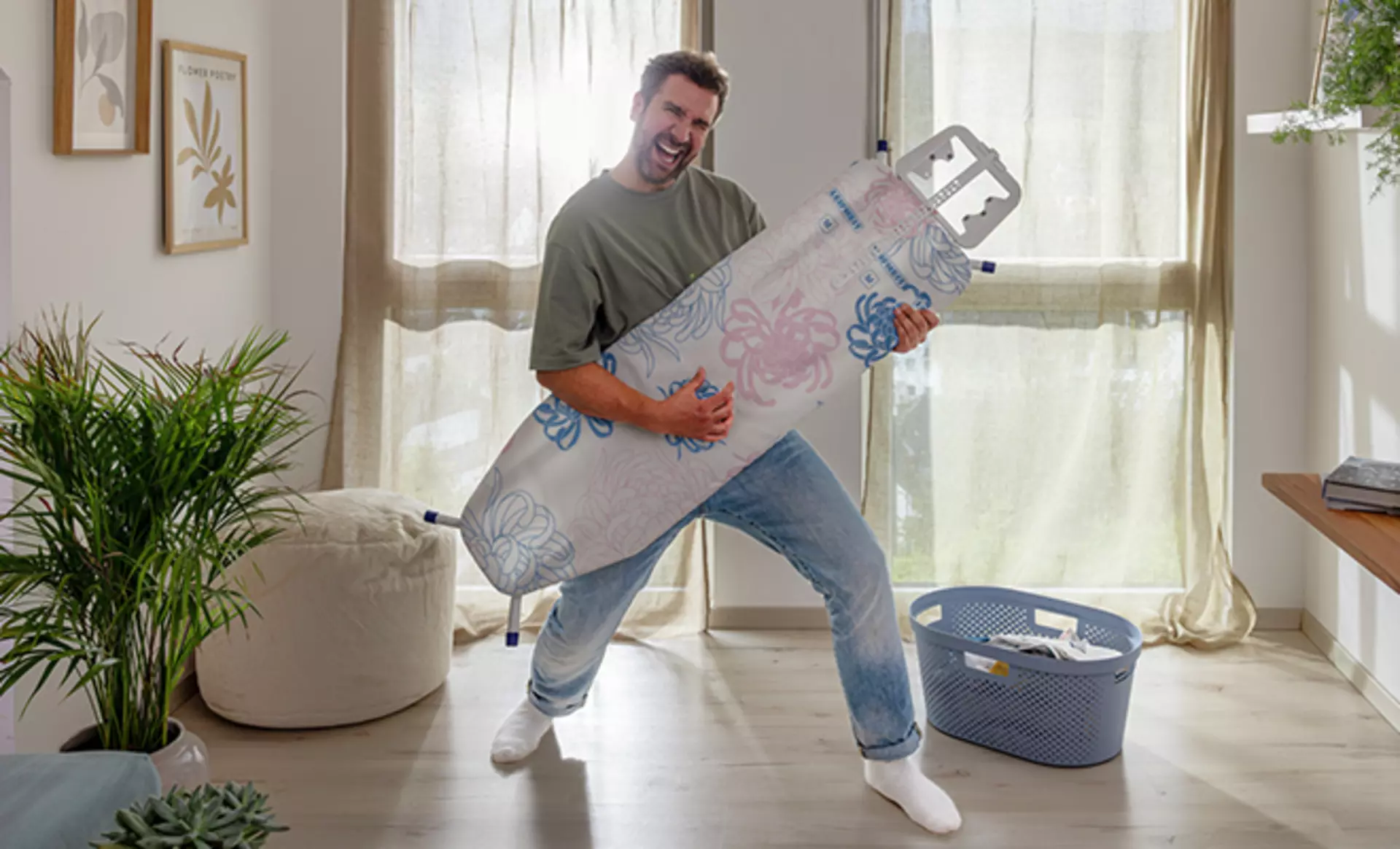 Mann spielt mit Leifheit Bügelbrett Luftgitarre