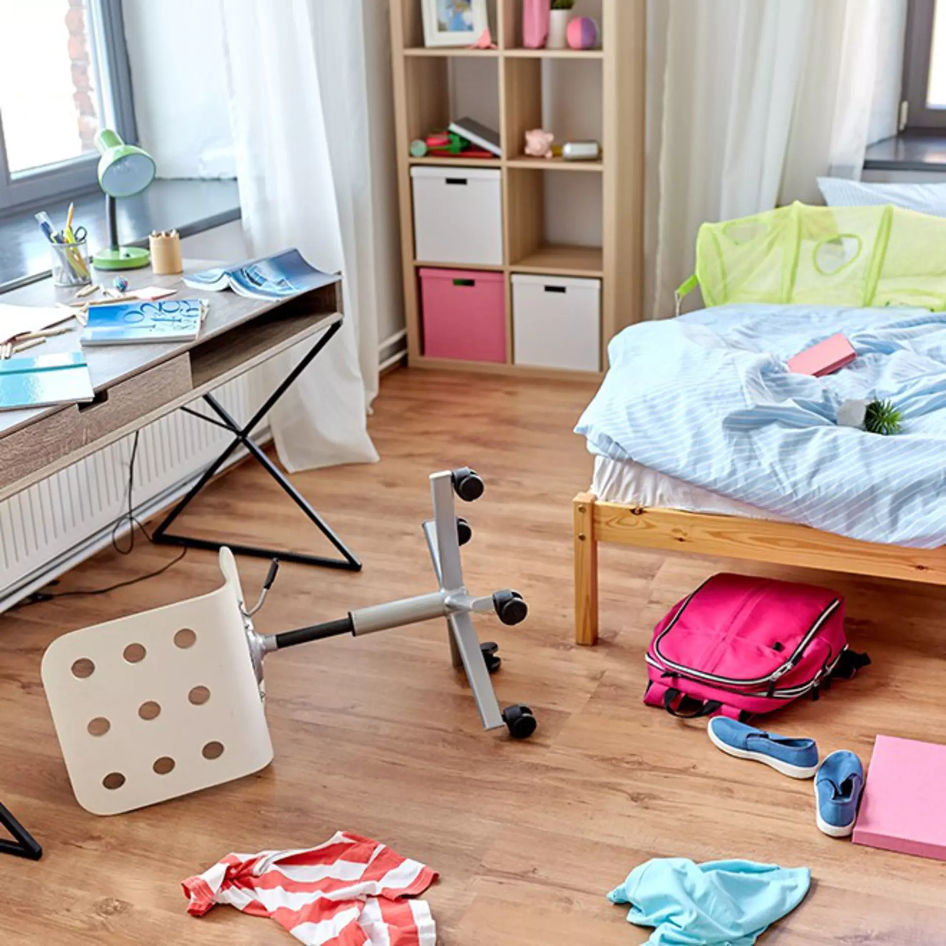 Unordentliches Kinderzimmer mit verschiedenen, nicht zusammenpassenden Möbeln.