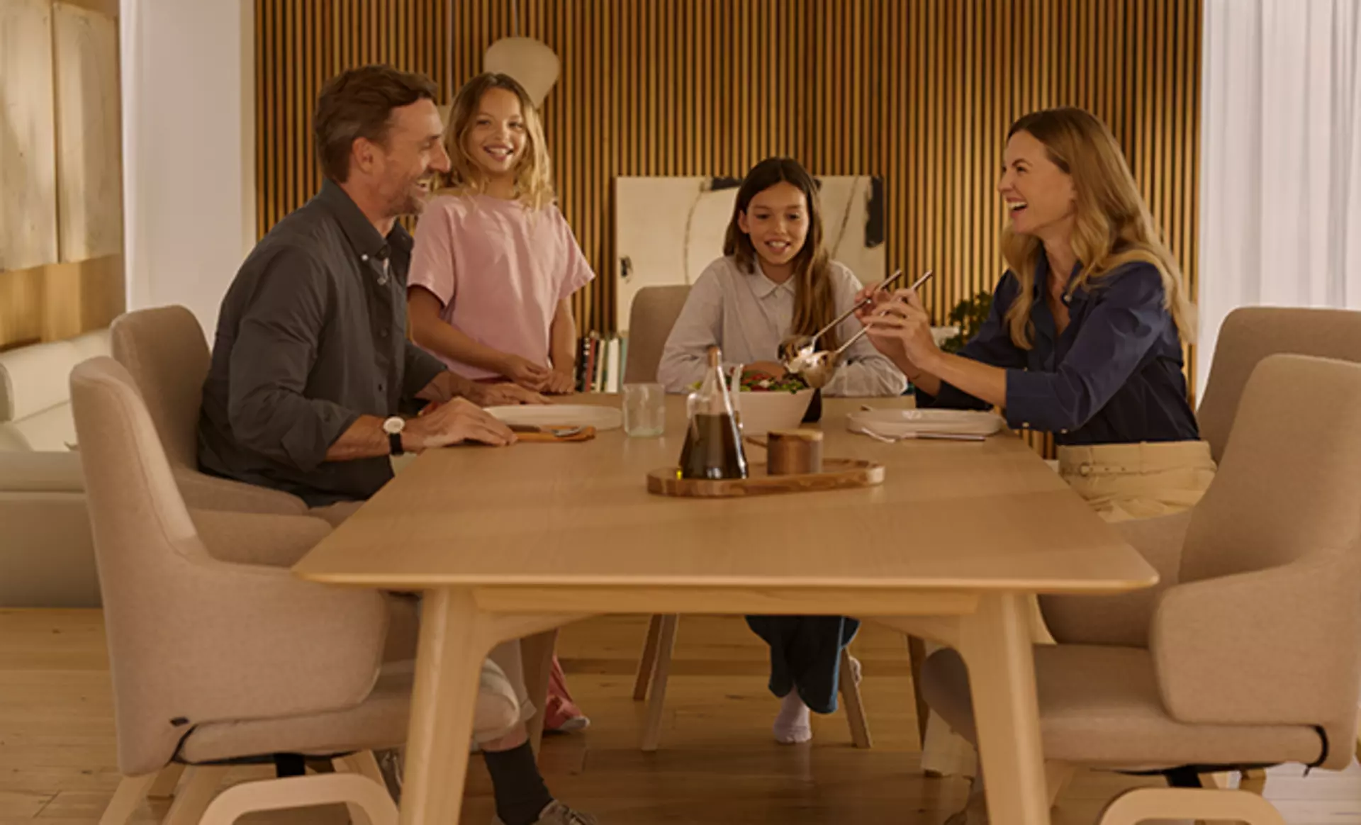 Eine Familie sitzt beim Essen an einem Stressless Esszimmertisch mit Stressless Esszimmerstühlen 