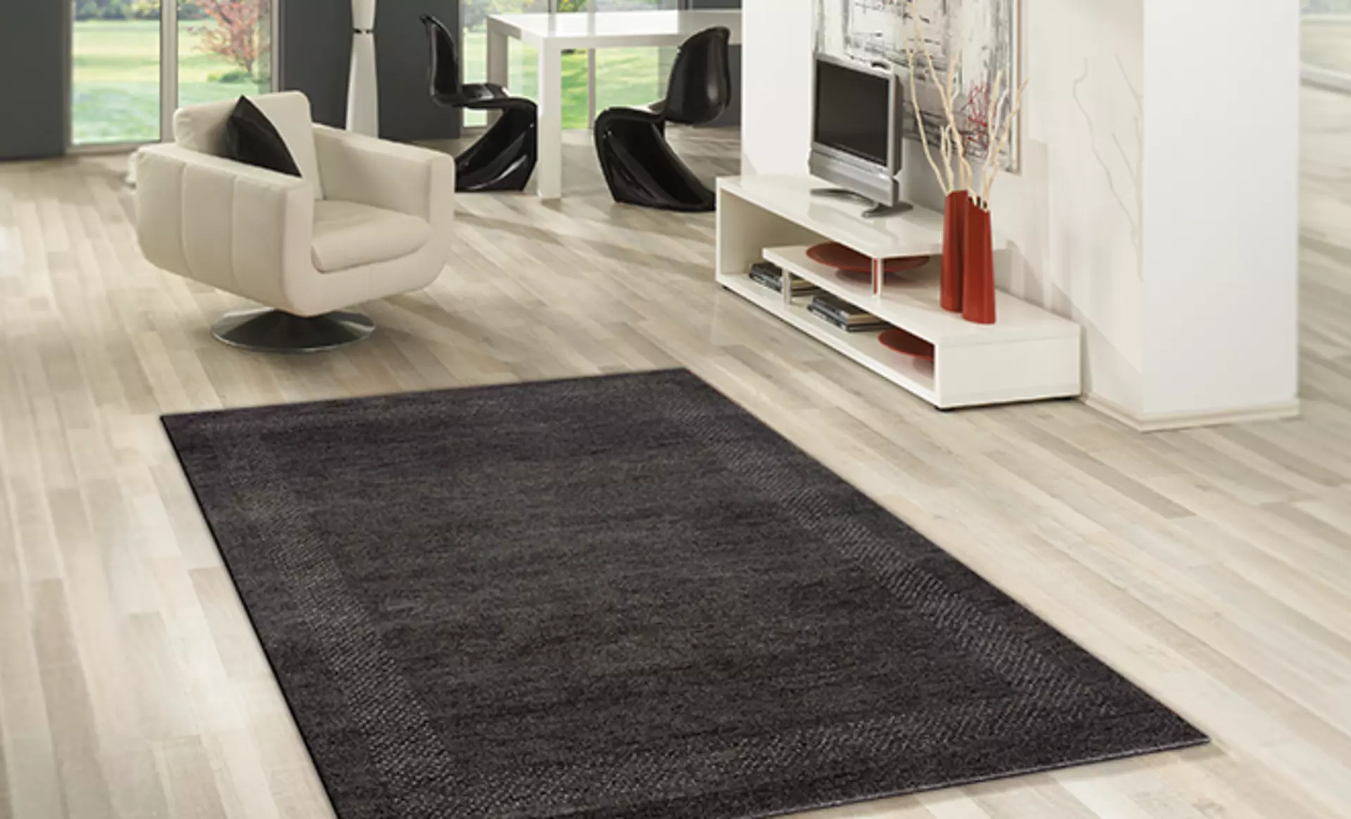 Der schlichte CAS Teppich von RUG Studios in anthrazit in einem modernen Wohnzimmer