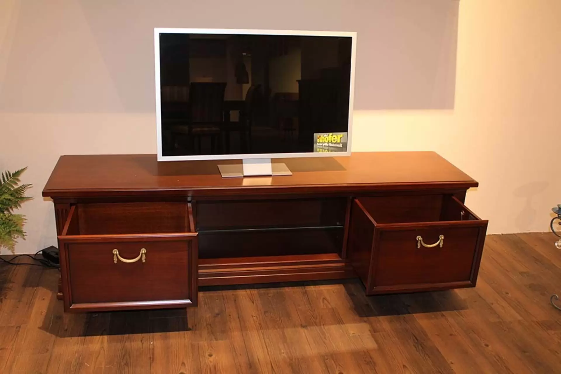 TV-Schrank aus dunklem Holz mit geöffneten Schubladen