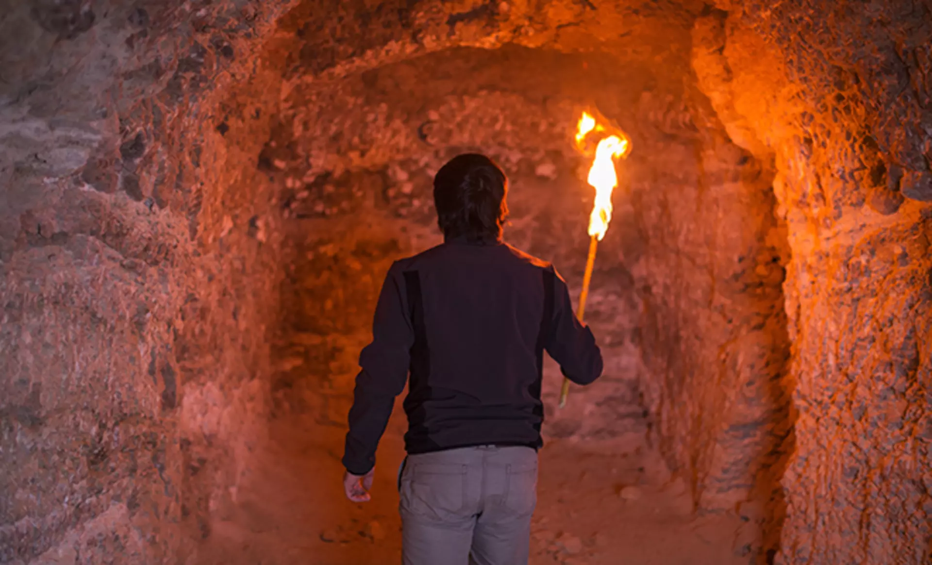 Mann in einer Höhle mit Fackel Man Cave von Möbel Inhofer