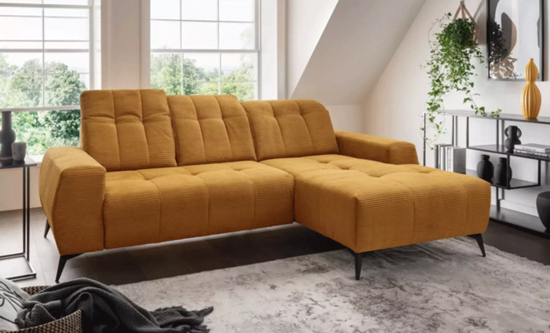 Trendiges Cordsofa in Senfgelb neben einem offenen Regal